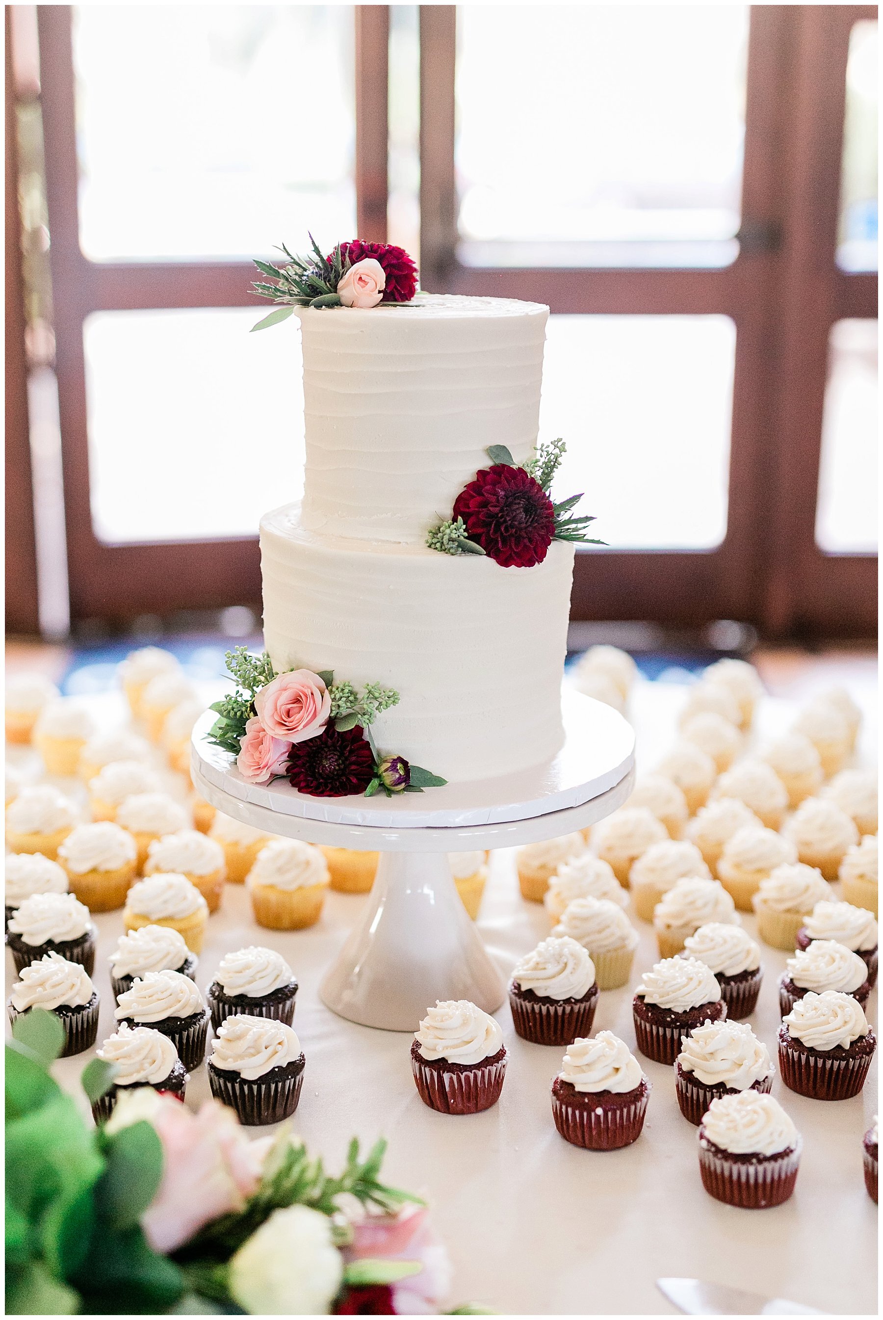  dessert table with wedding cake decorated with maroon flowers 