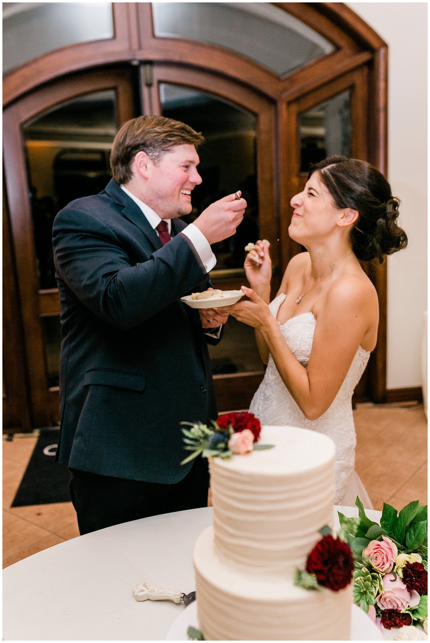  bride and groom feeding one another cake 