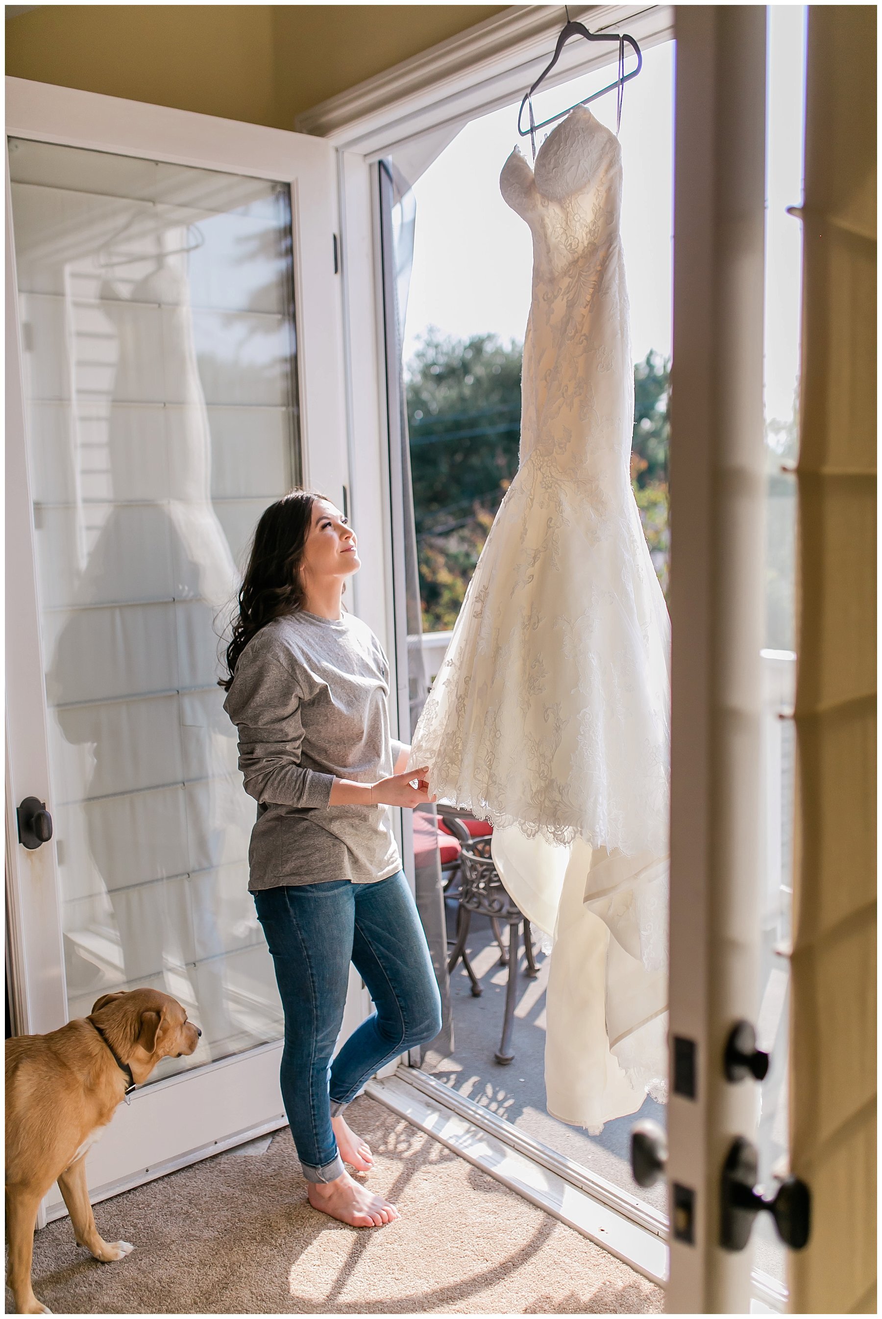  bride looking at her wedding dress in the doorway of the balcony 
