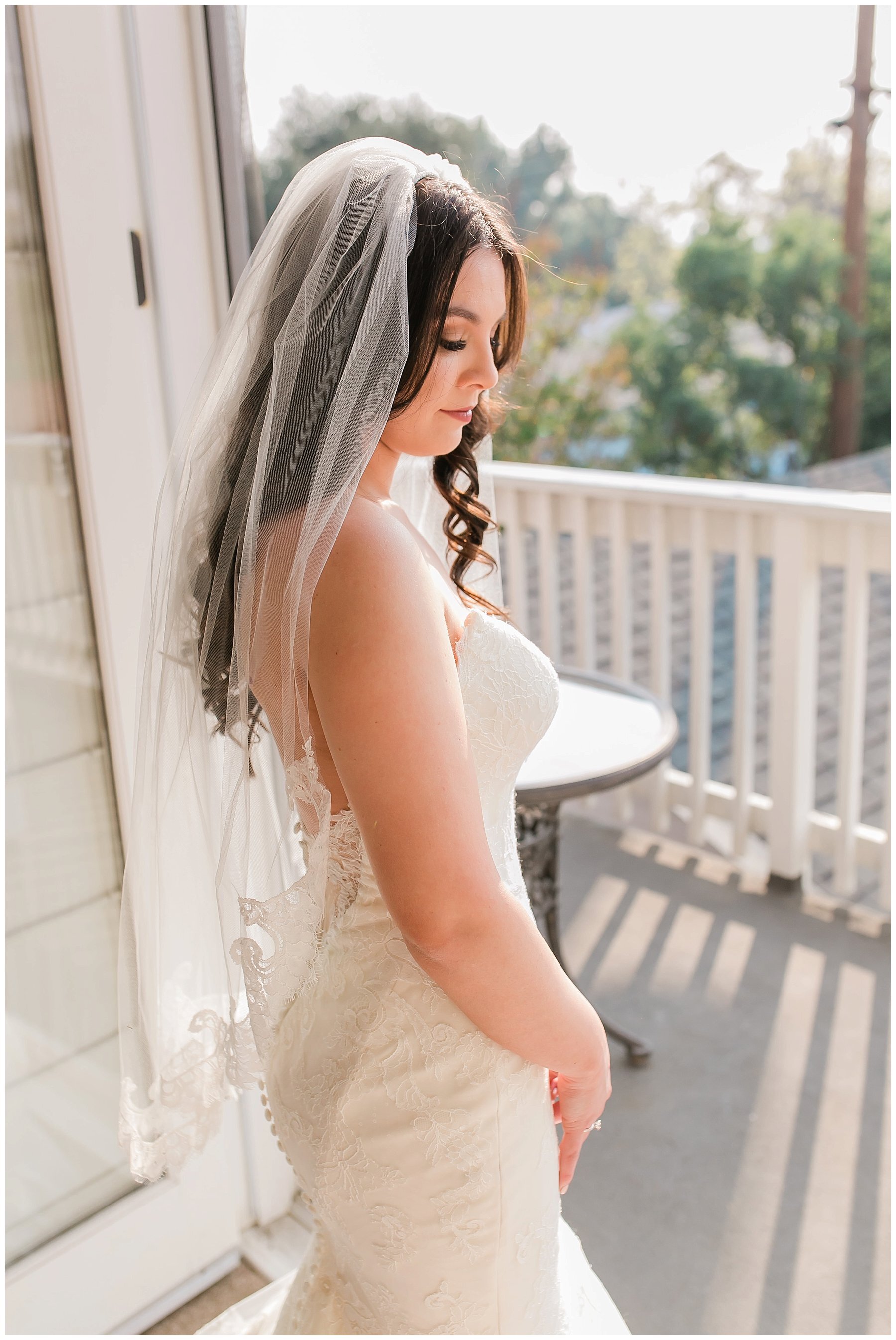  bride looks over her shoulder with the balcony in the background 