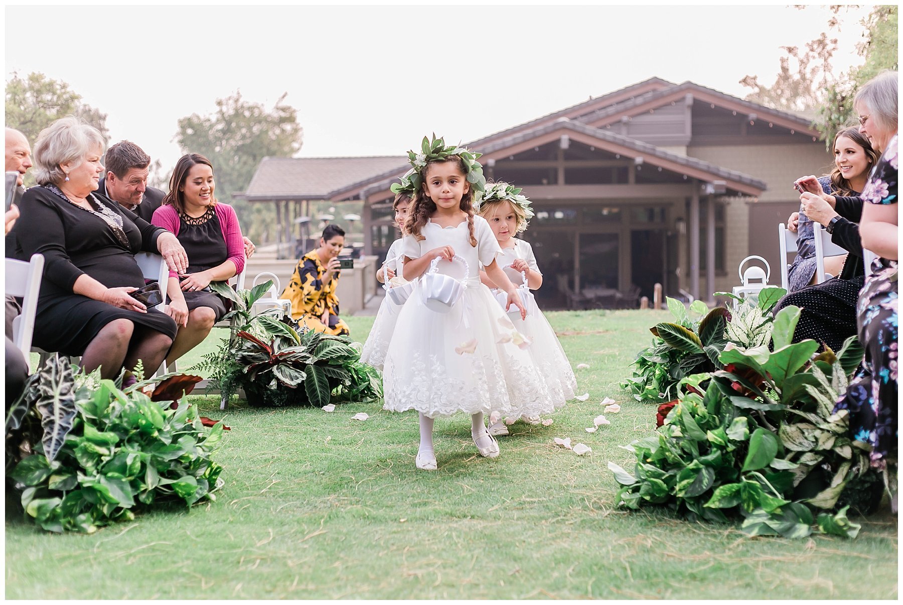  flower girls walking down the aisle with leaf crowns 