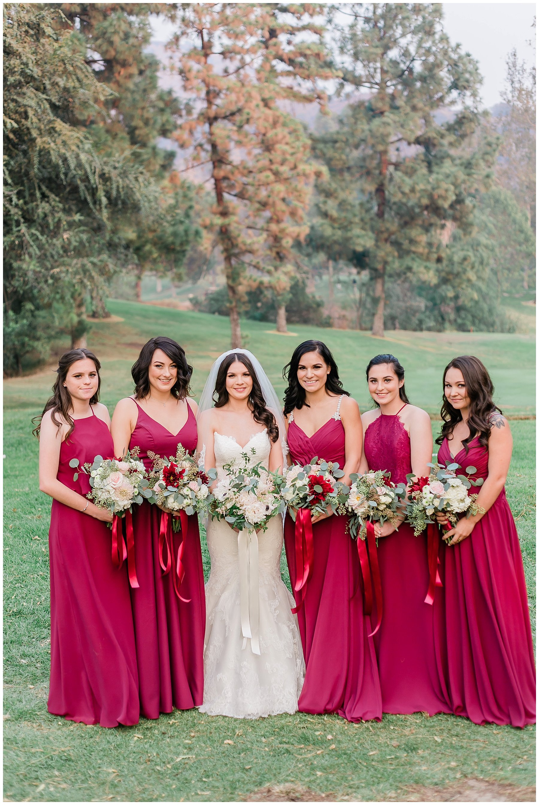  bride and her bridesmaids in front of the golf course trees and greenery 