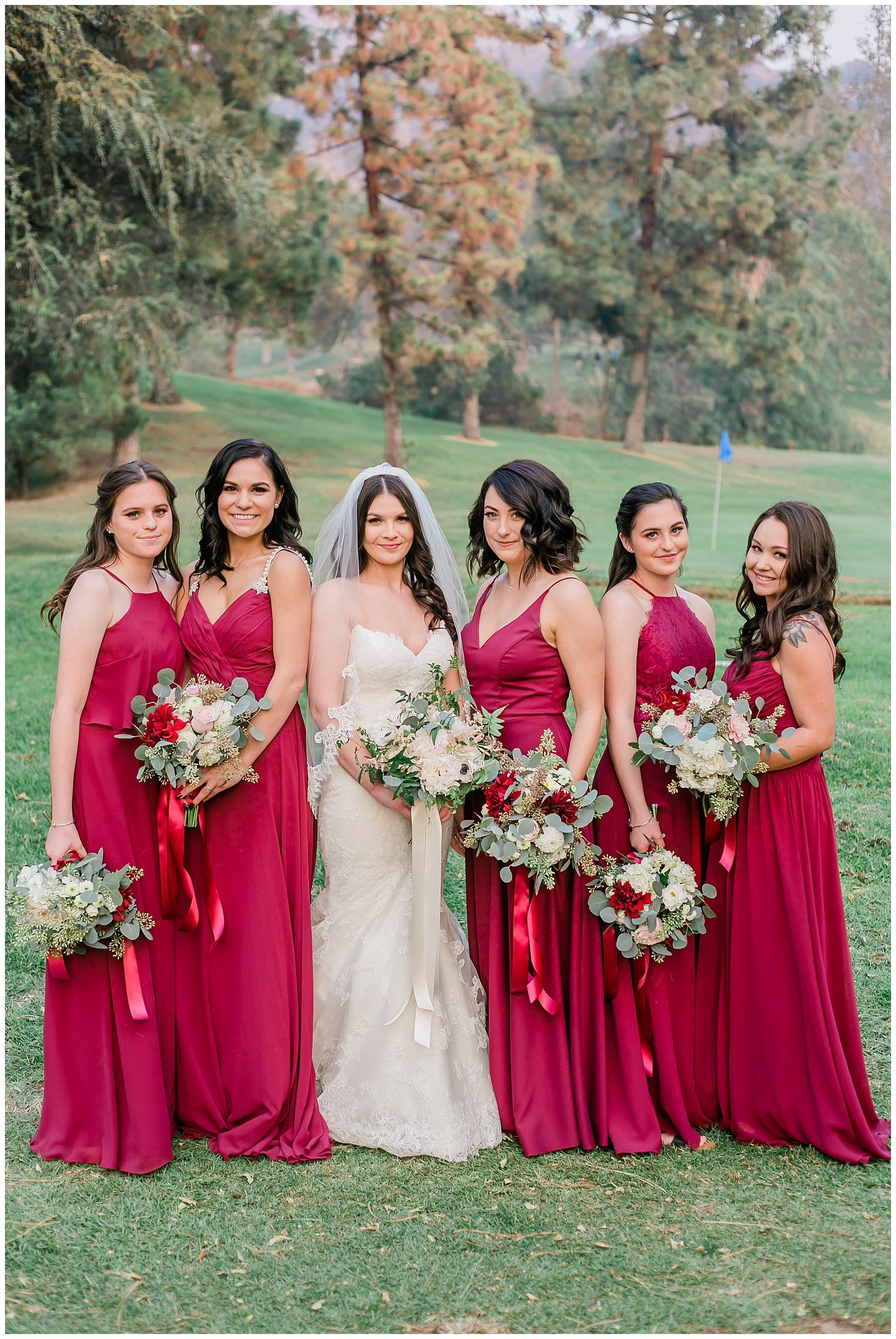  bride and bridesmaids standing on the golf course holding bouquets 