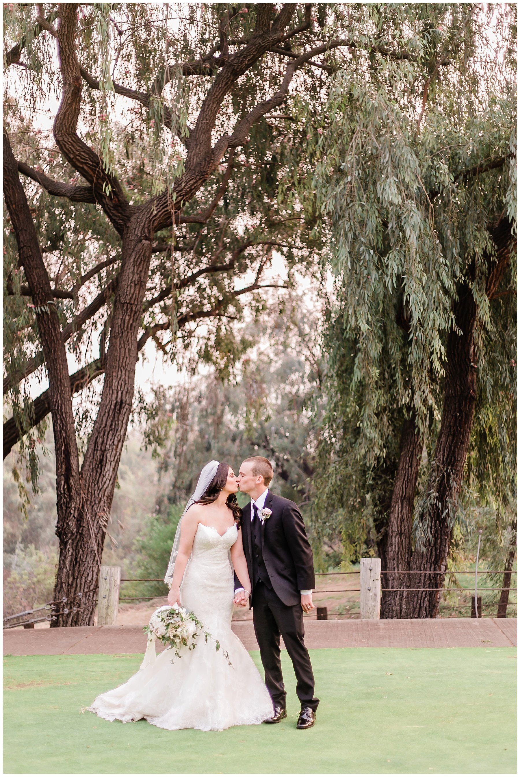  bride and groom kiss in front of the trees on the golf course 