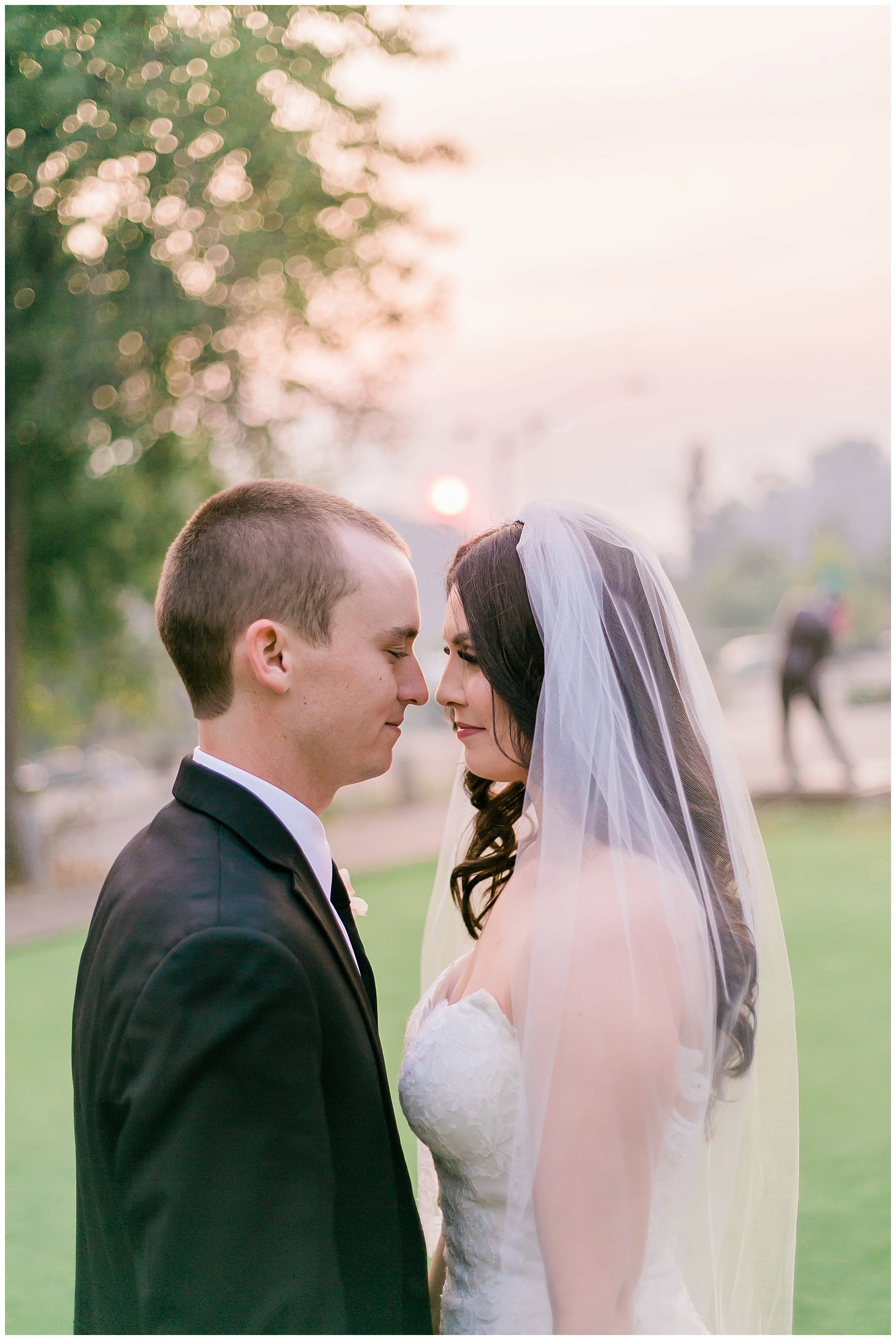  bride and groom with their faces close to one another and the sun setting behind them 