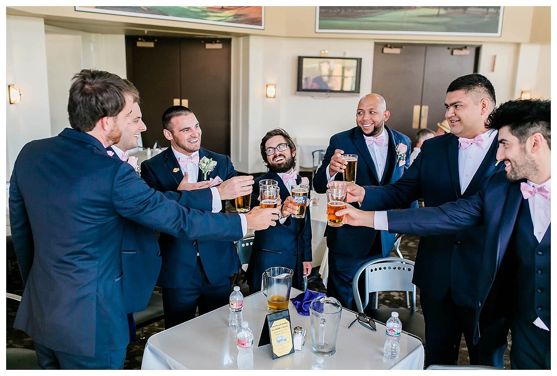  groomsmen toasting beers in the groom’s suite 