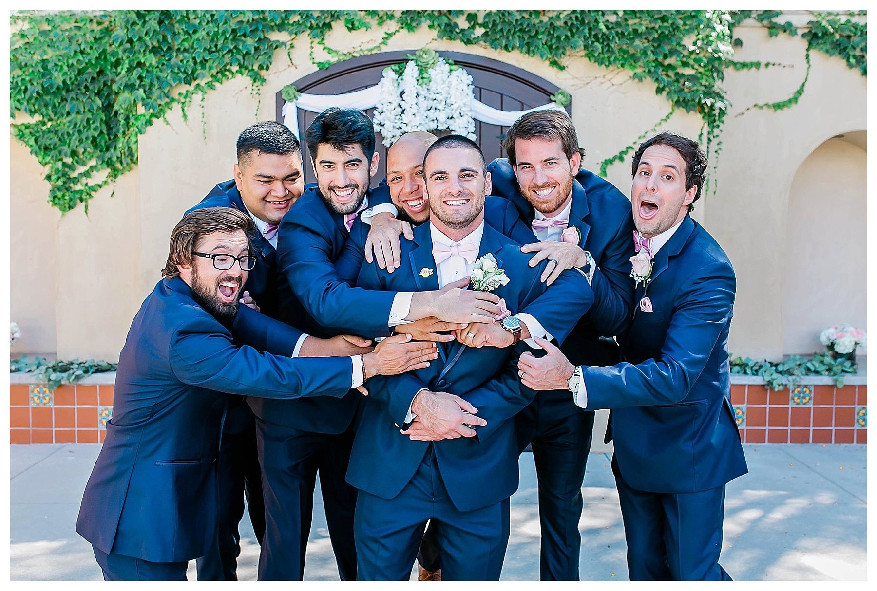  groomsmen hyping up the groom in front of the venue entrance 