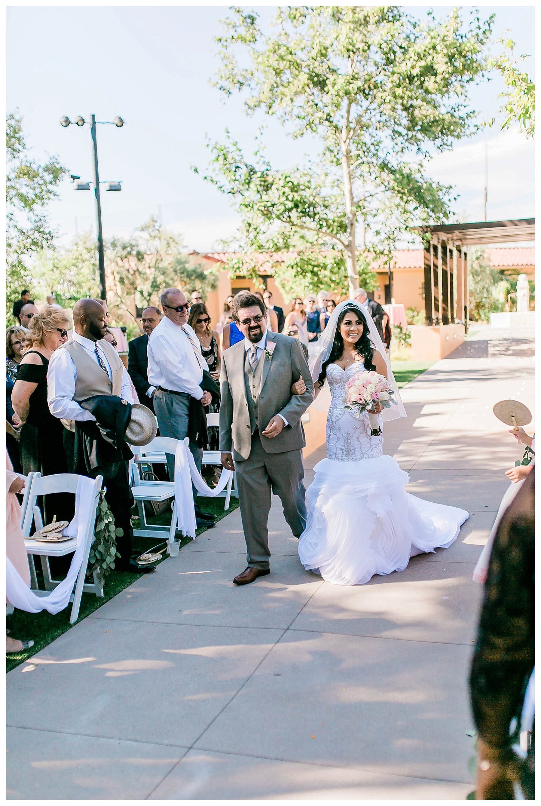  bride walks down the aisle on the arm of her father 