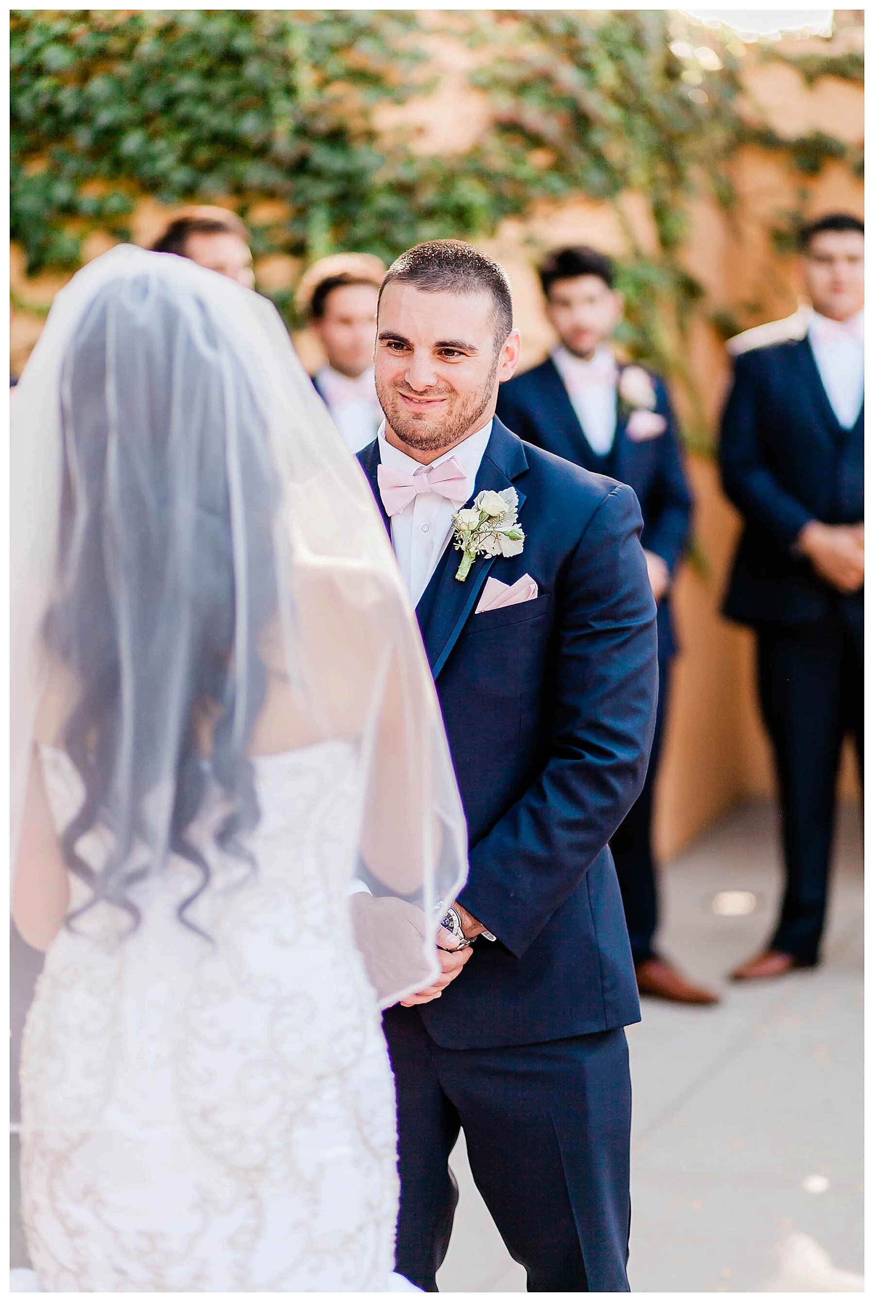  groom looking at his bride as they stand at the altar 