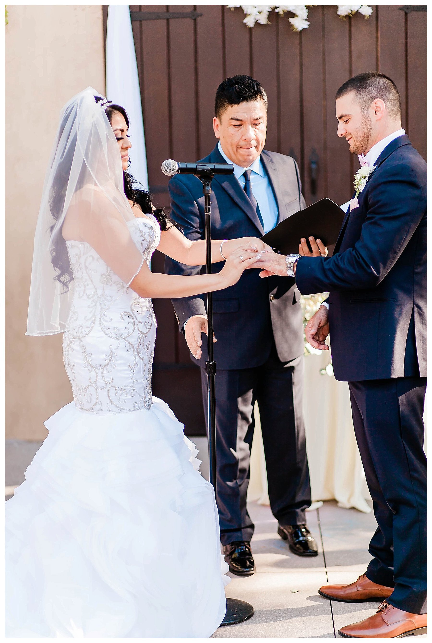  bride puts ring on her grooms finger at the altar 