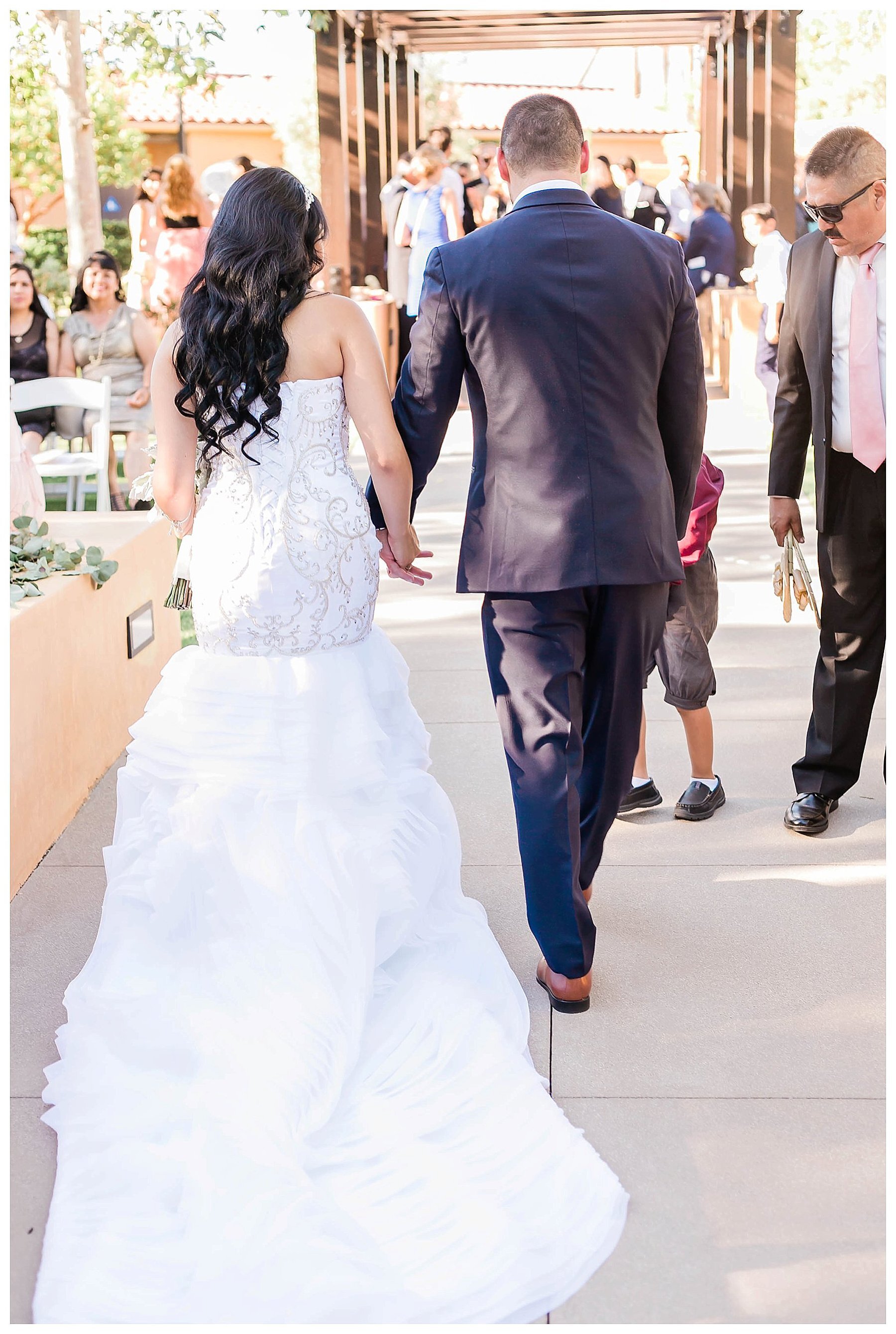  bride and groom walking down the aisle holding hands 