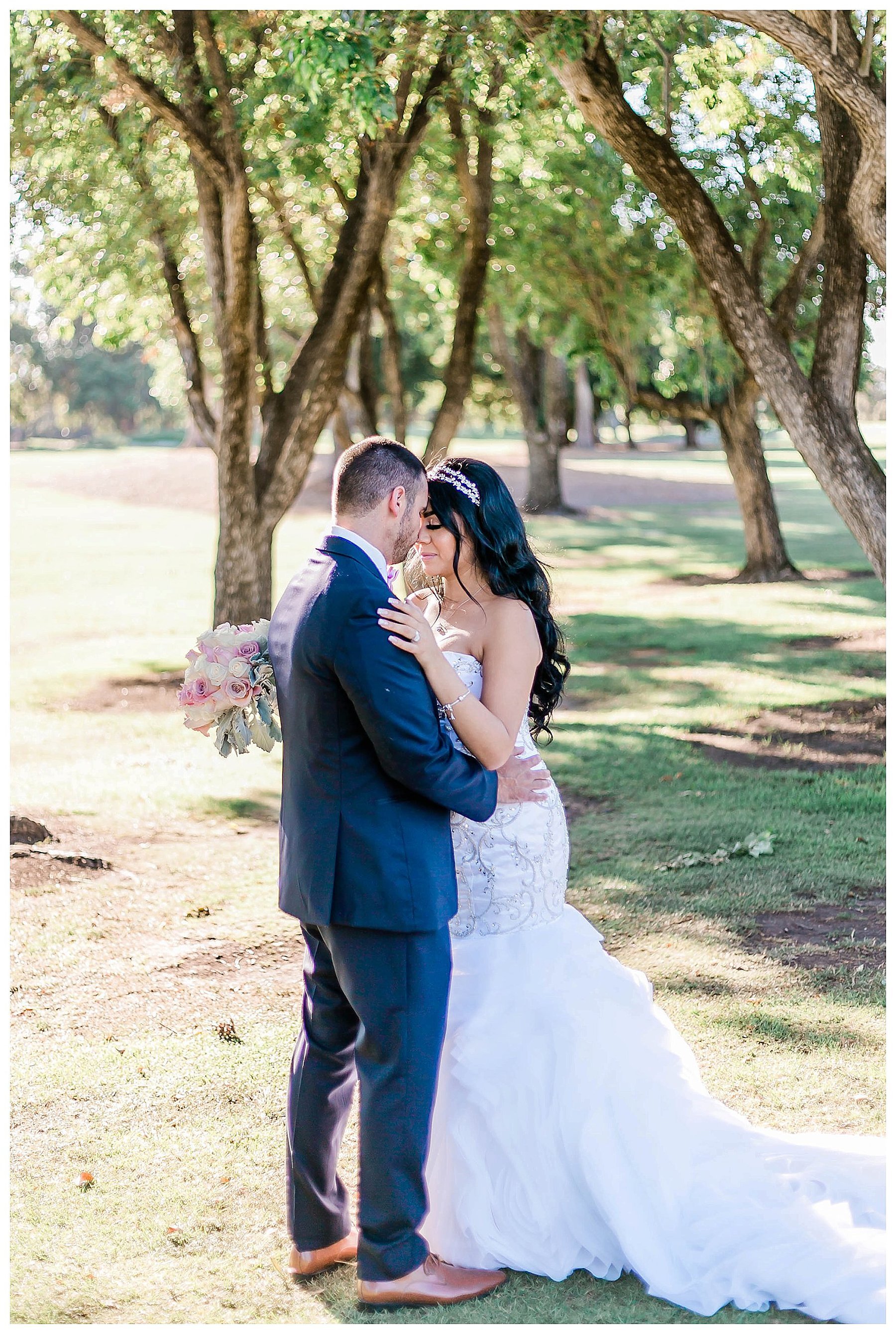  bride and groom touch foreheads in front of the trees 