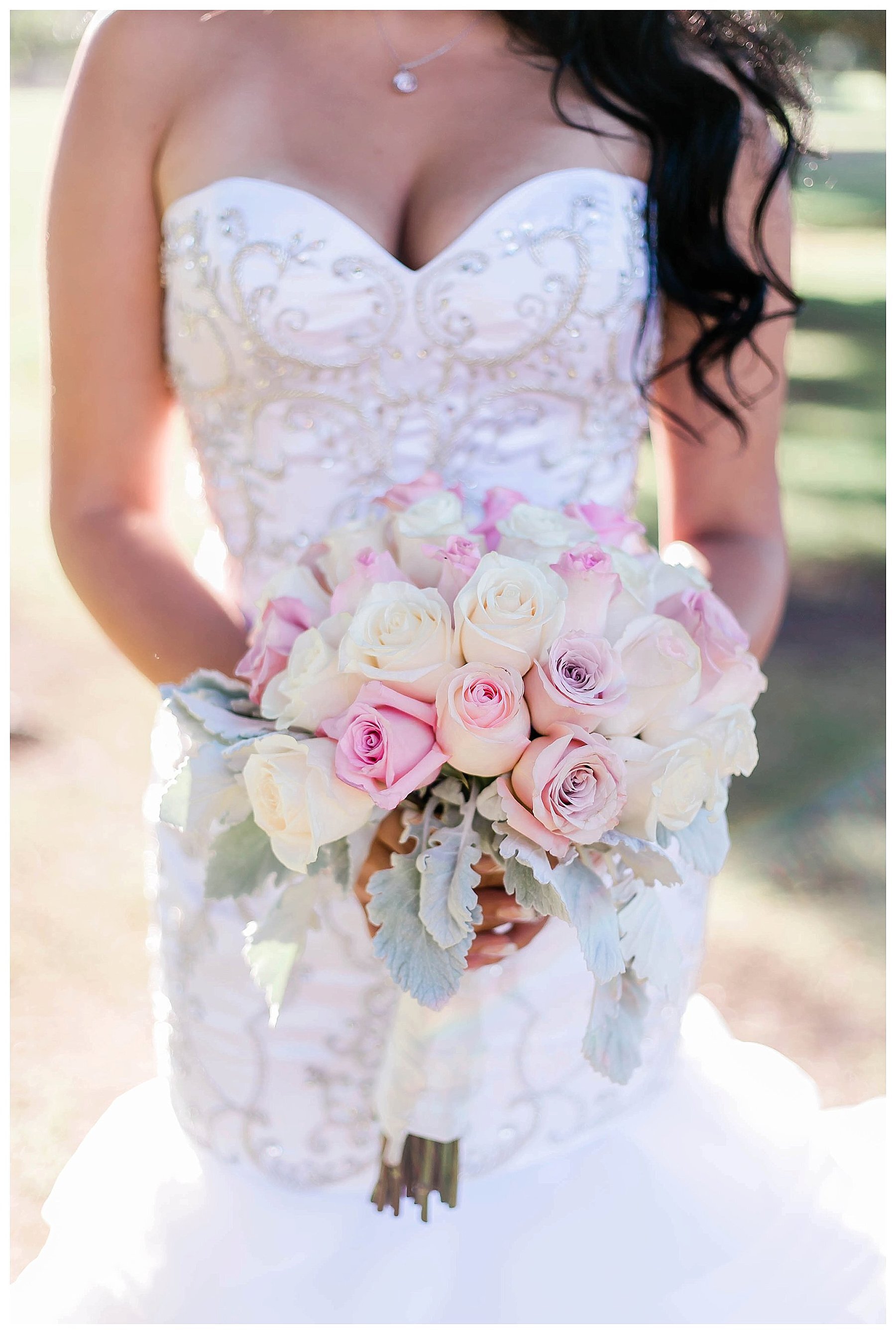 bride holds a pink and white bouquet in front of her waist 