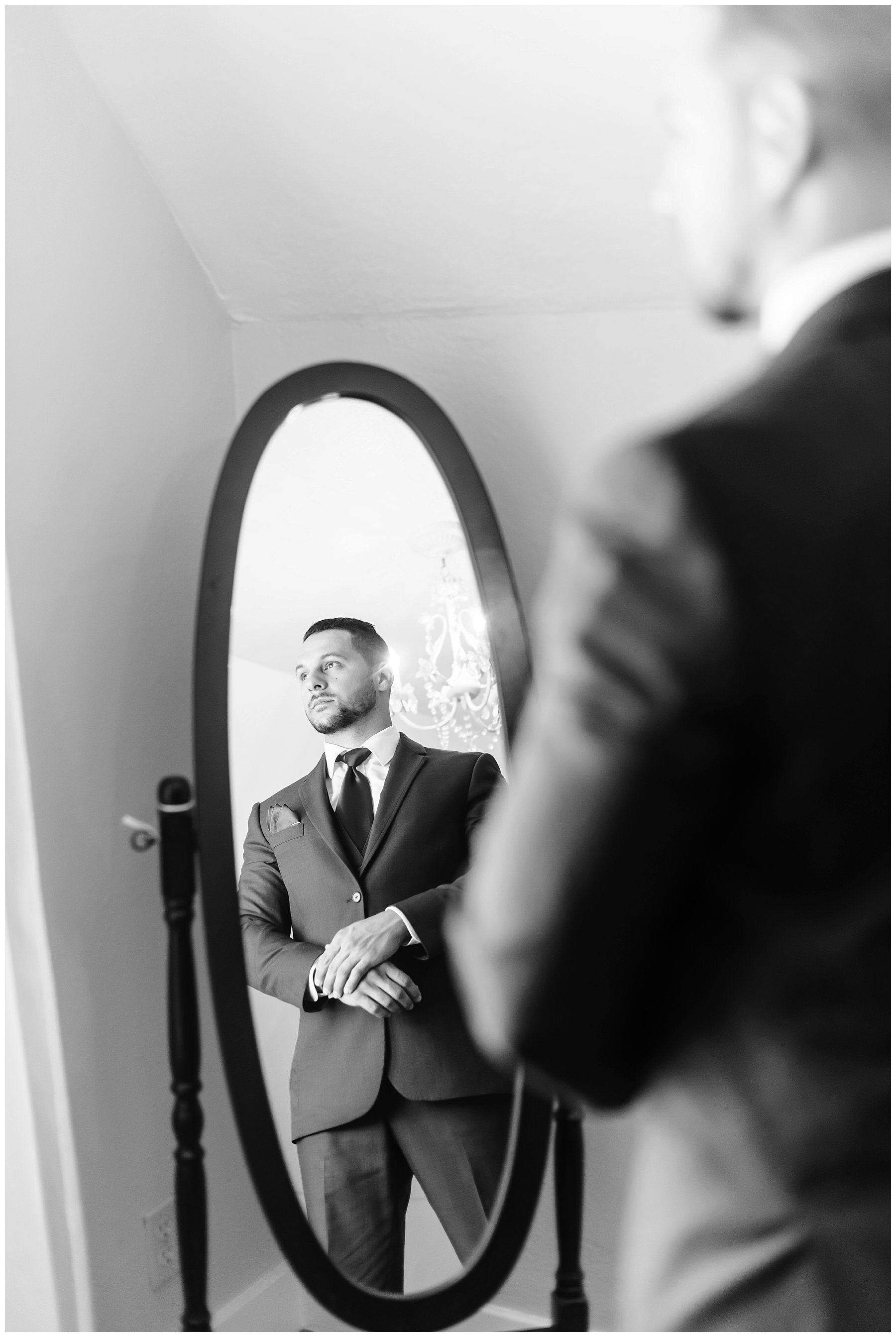  groom getting ready in the mirror 