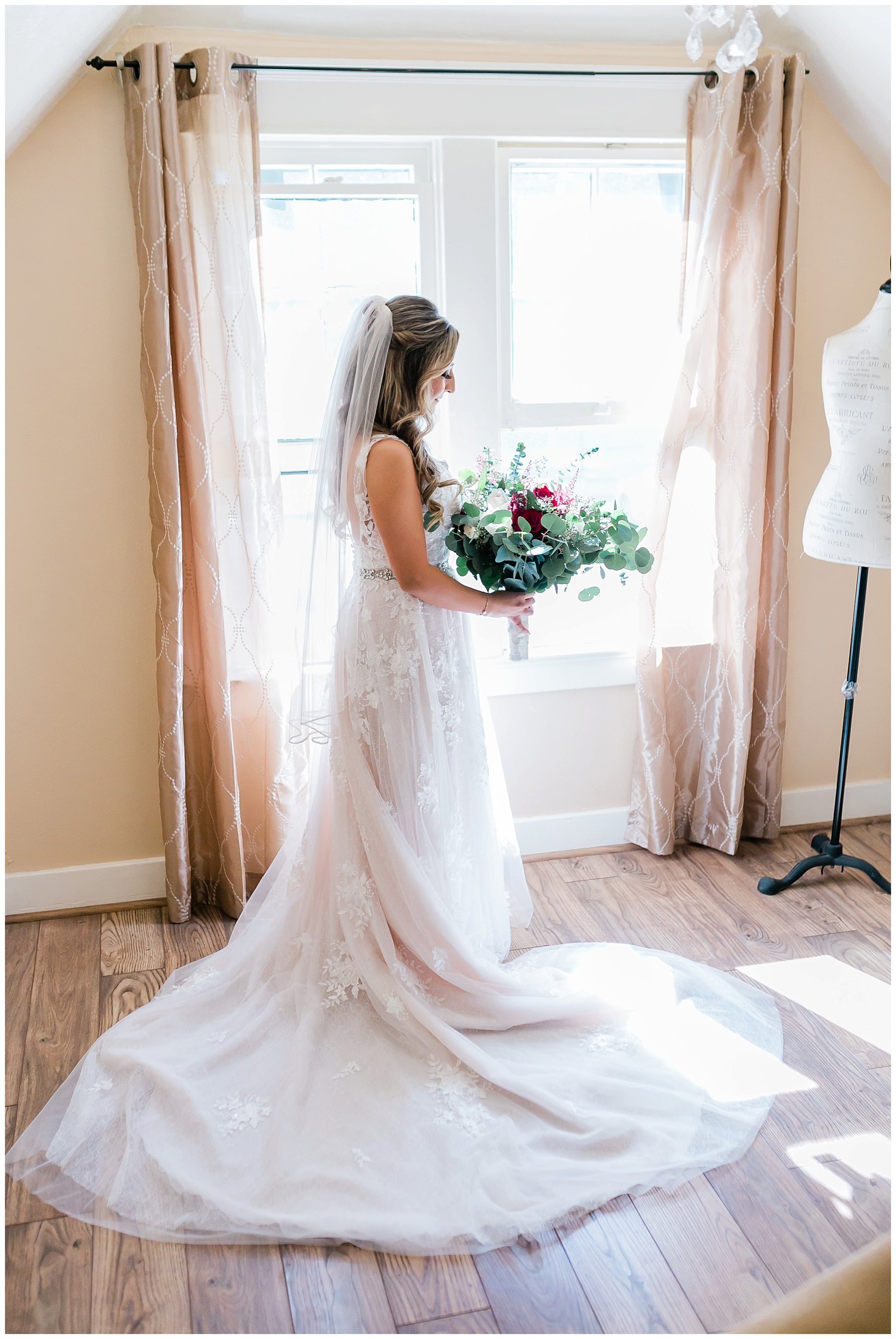  bride holding her bouquet in the light from the window 
