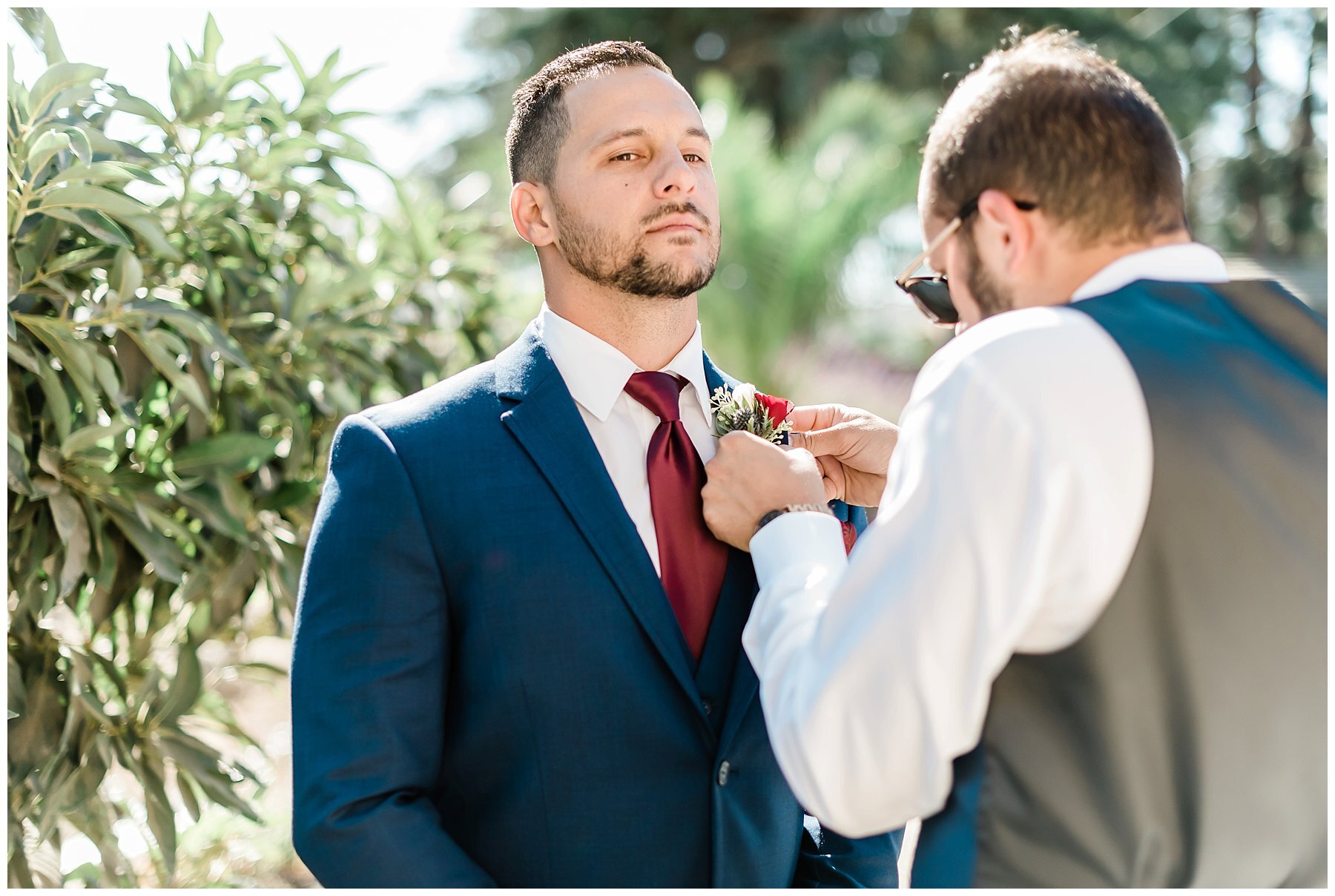  best man helping groom with flower 