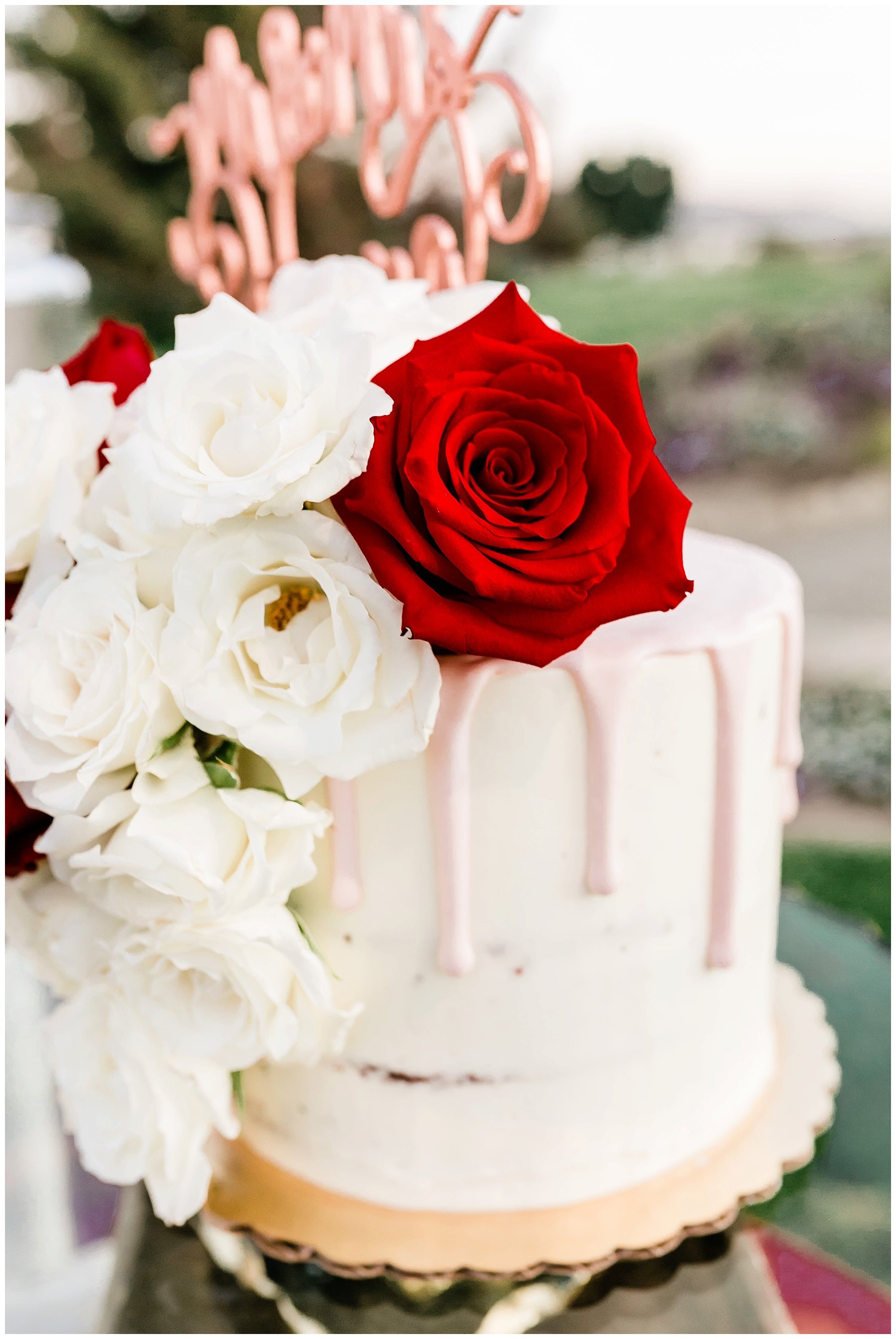  white wedding cake with red flowers and decor 
