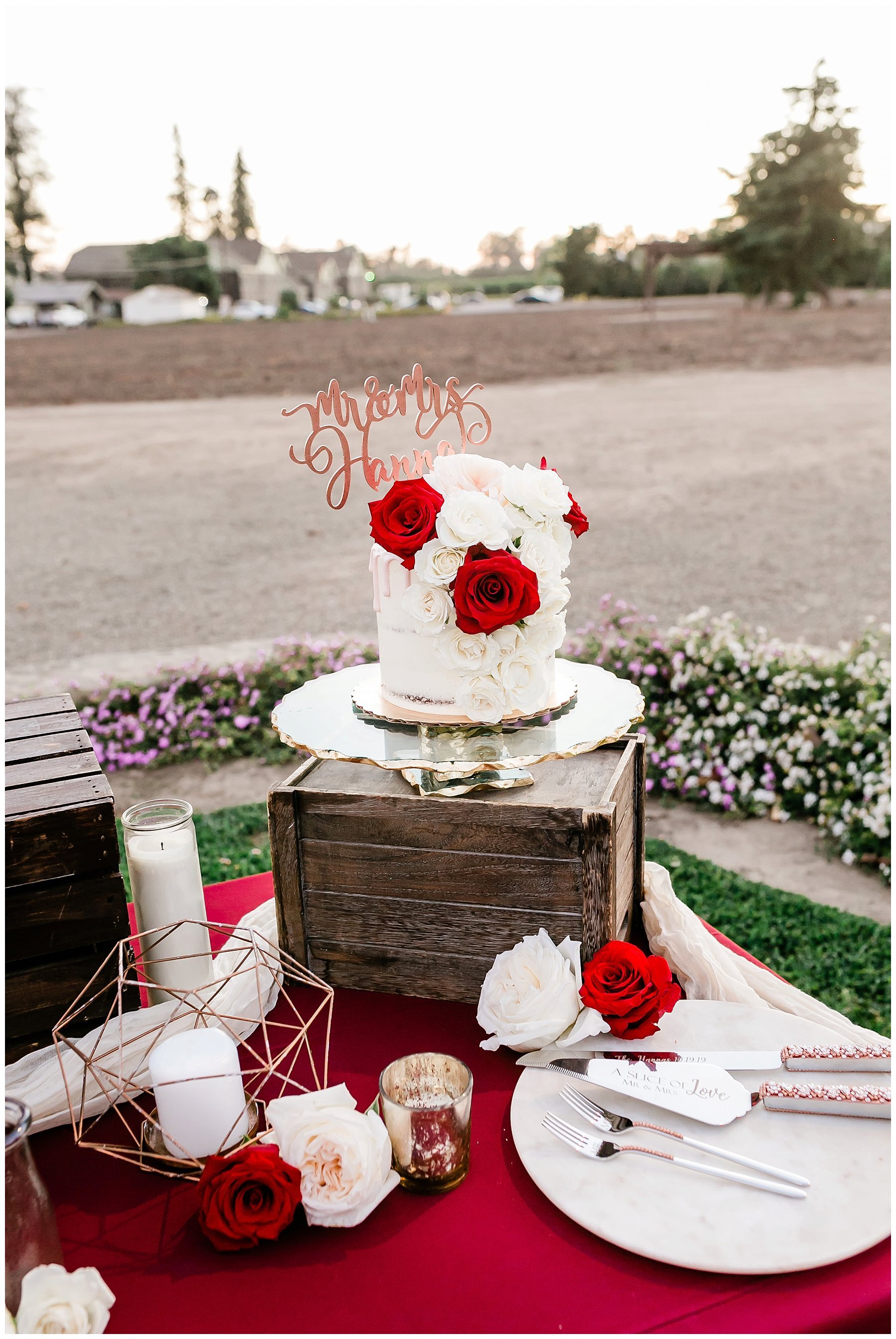 white wedding cake with red flowers and decor 