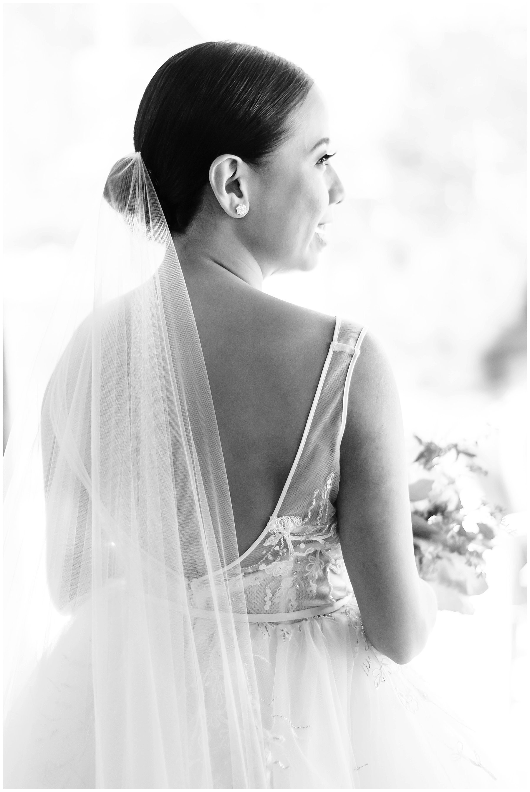  bride standing in the window light in her gown 