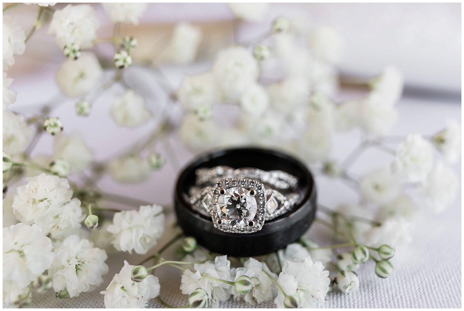  wedding bands sitting atop white flowers 