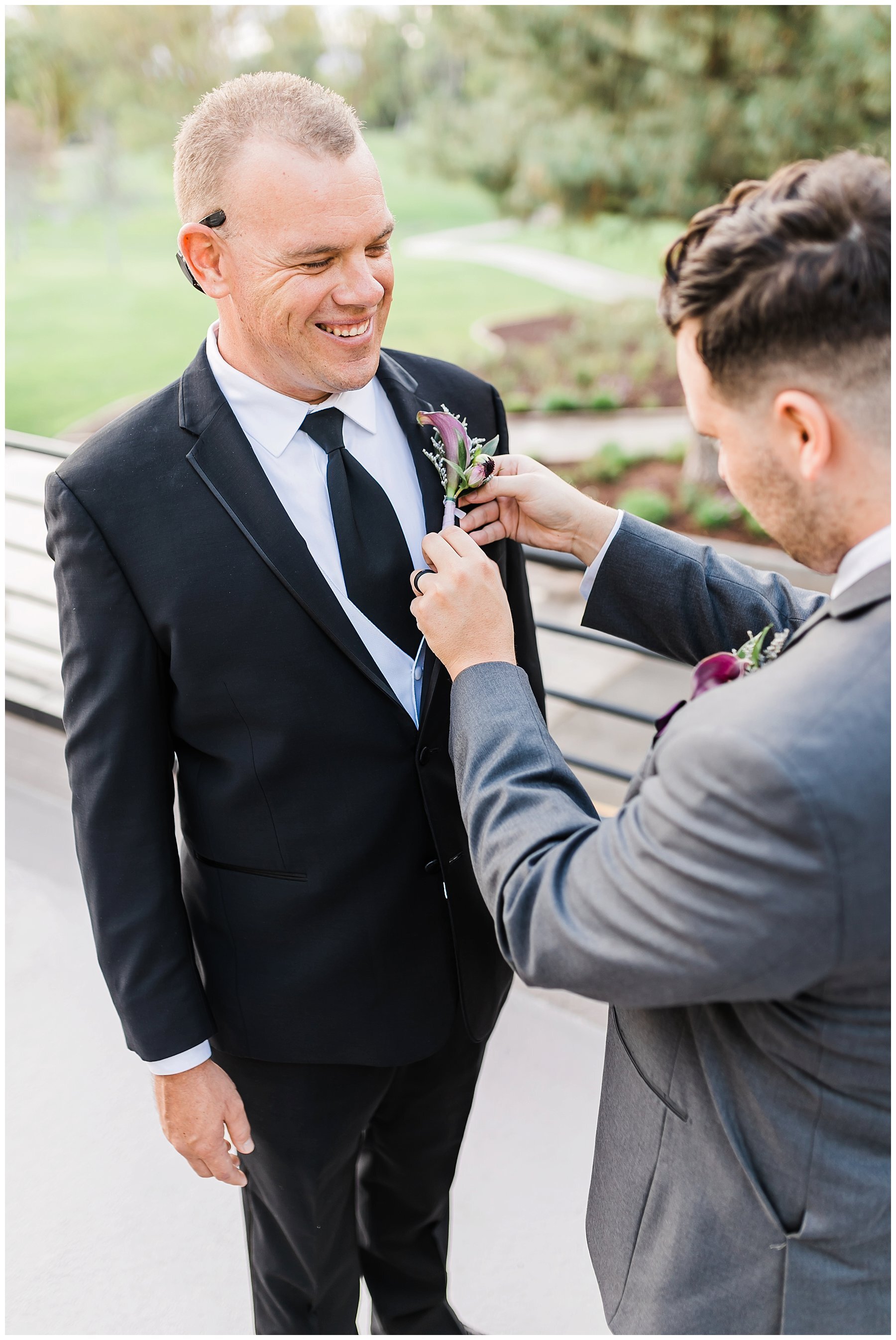  best man helping groom with boutonniere 