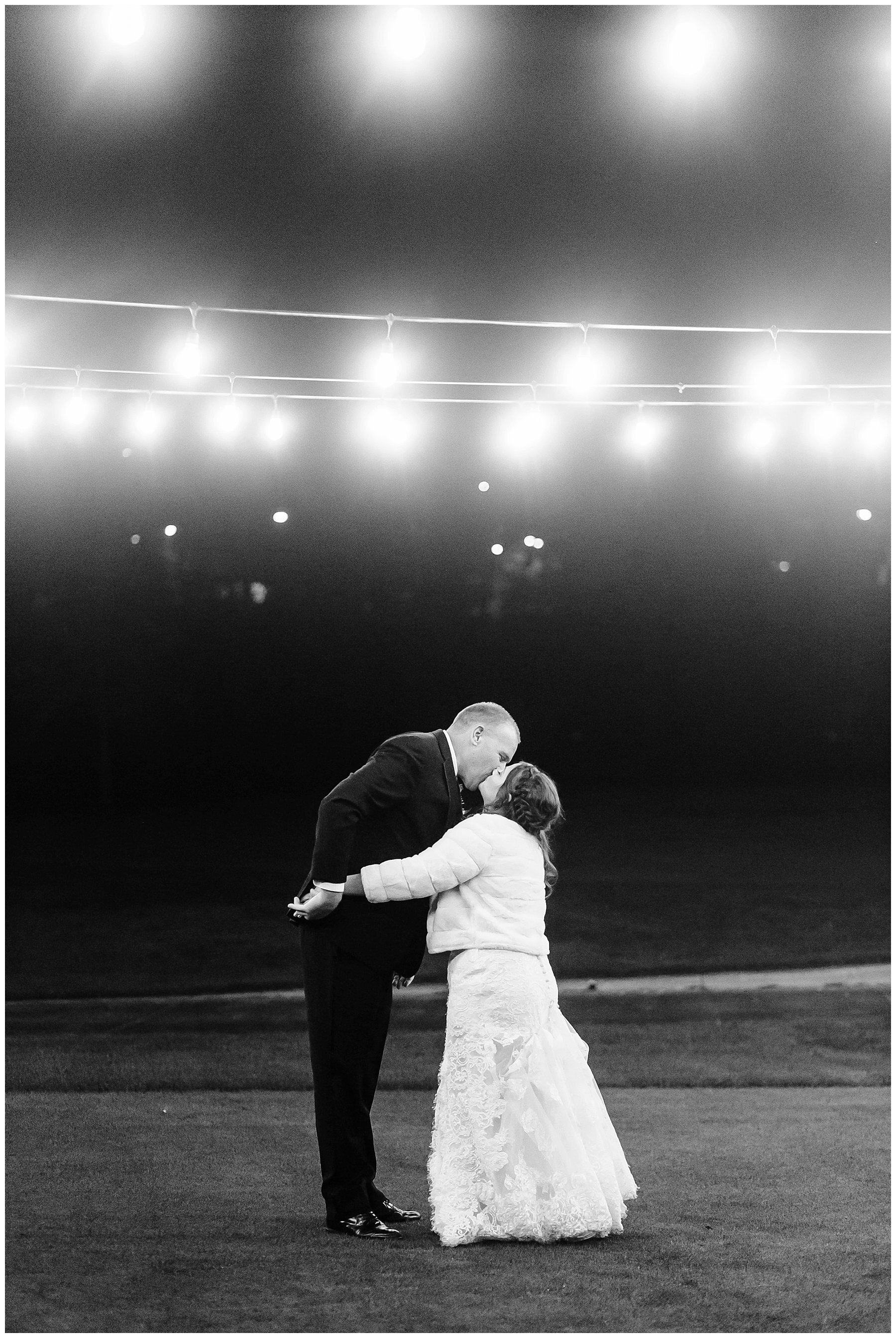  bride and groom kissing under the lights 