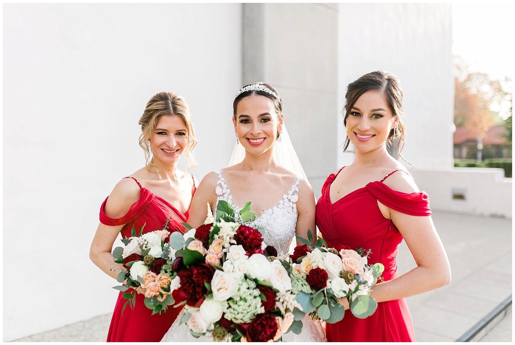  bride and bridesmaids in front of white building 