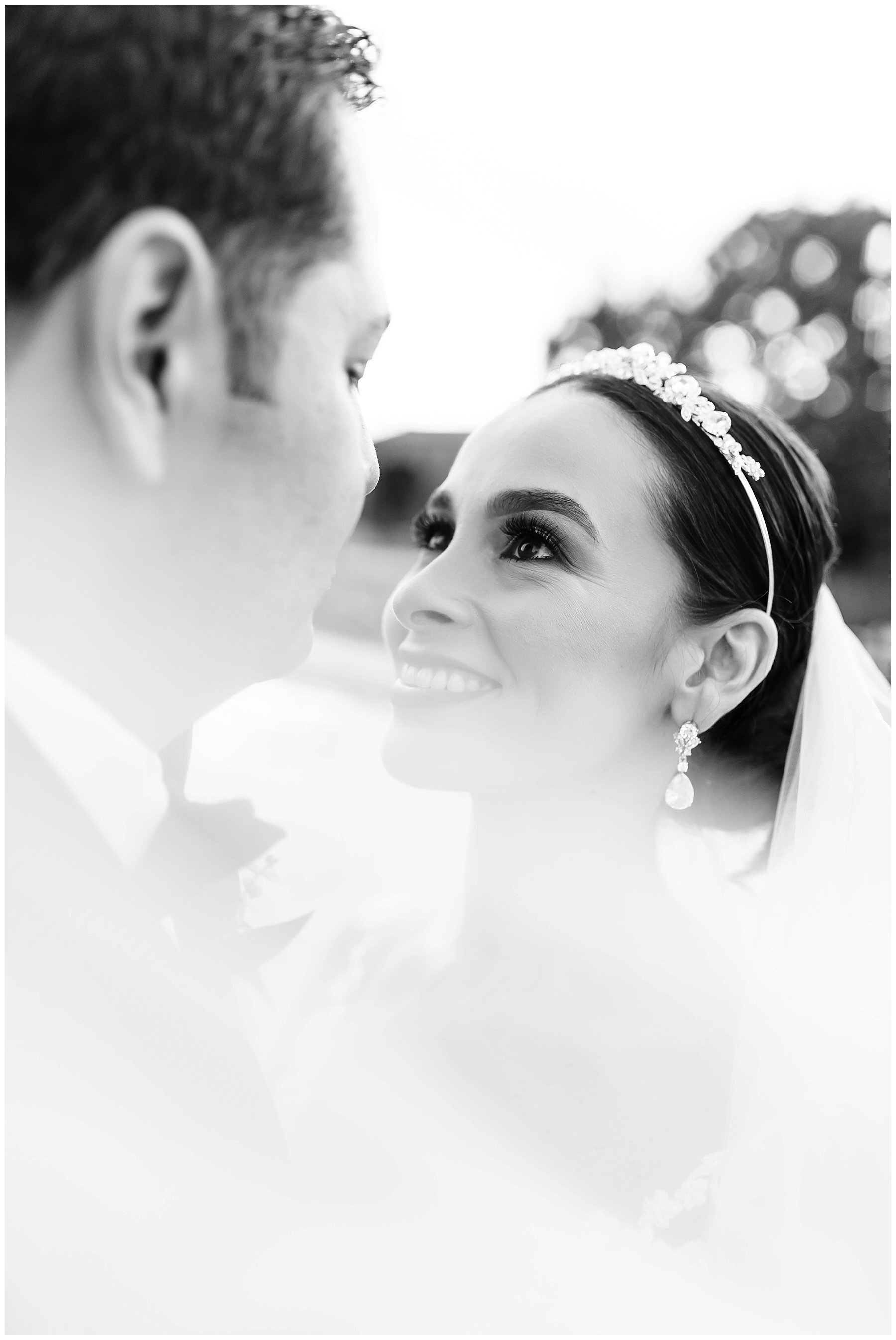  black and white photo of bride and groom looking at one another 