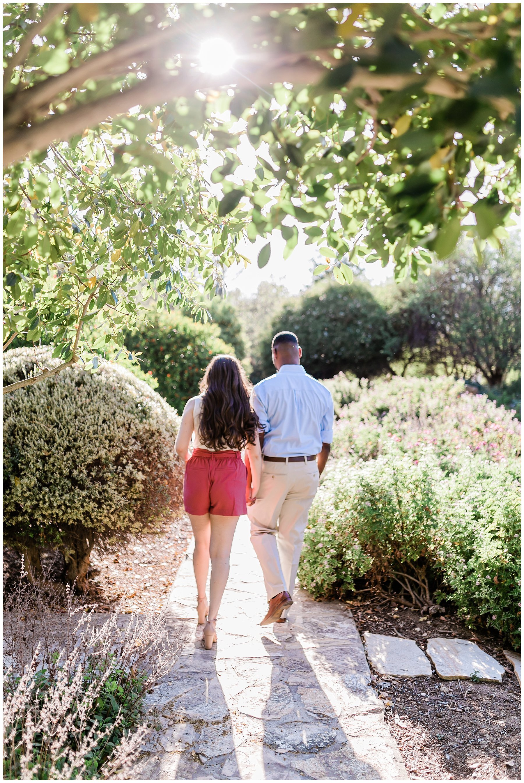  engaged couple walking through a garden 