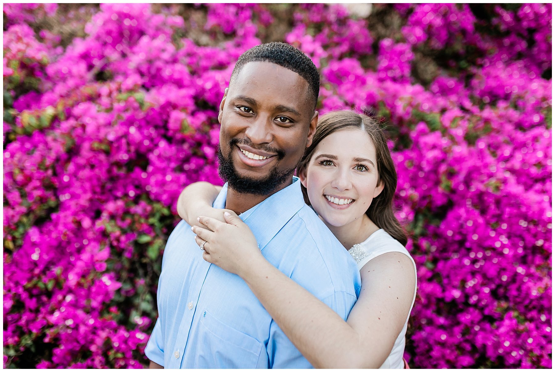  engaged couple in front of pink flowers 