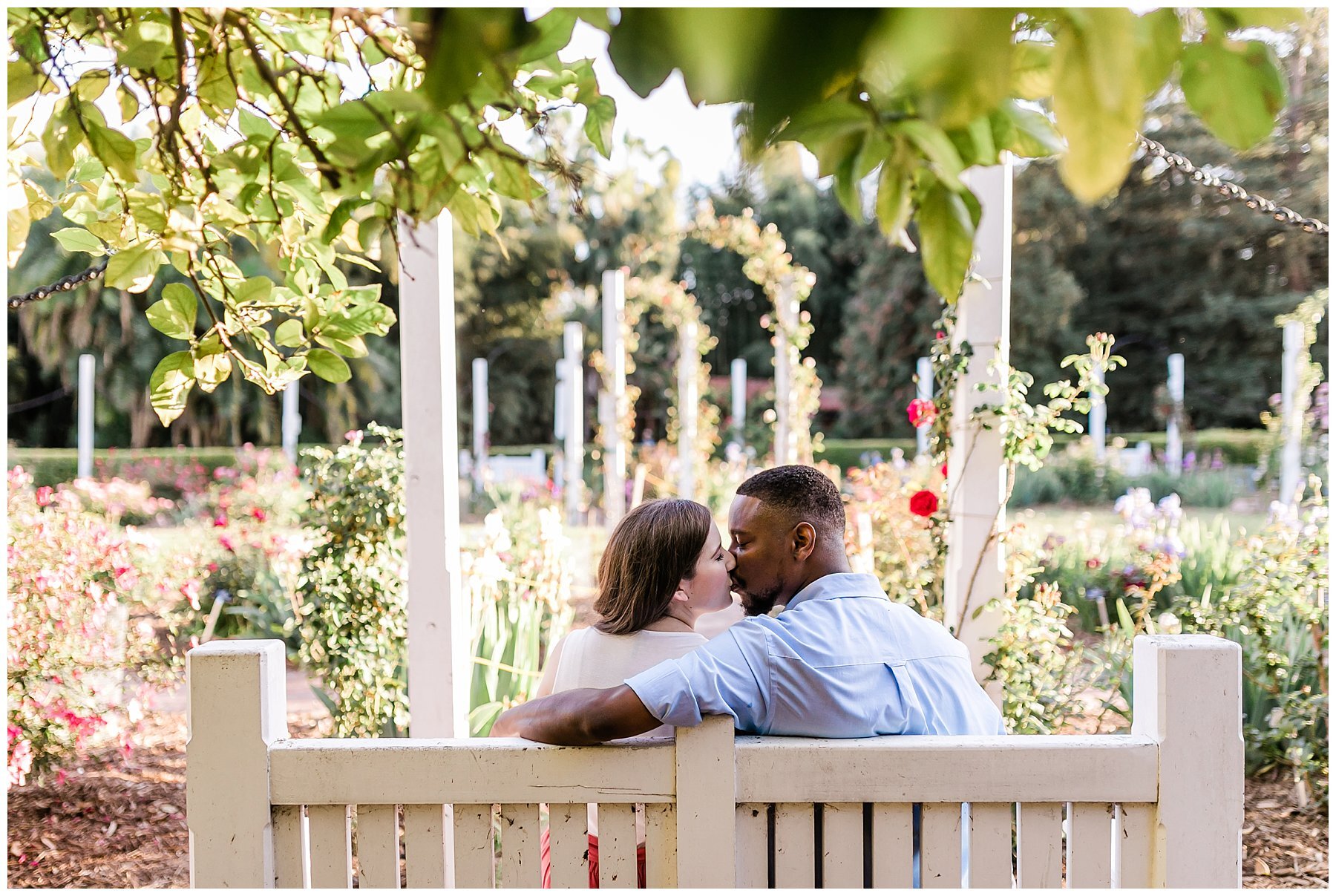  engaged couple sitting on a bench in front of the garden 