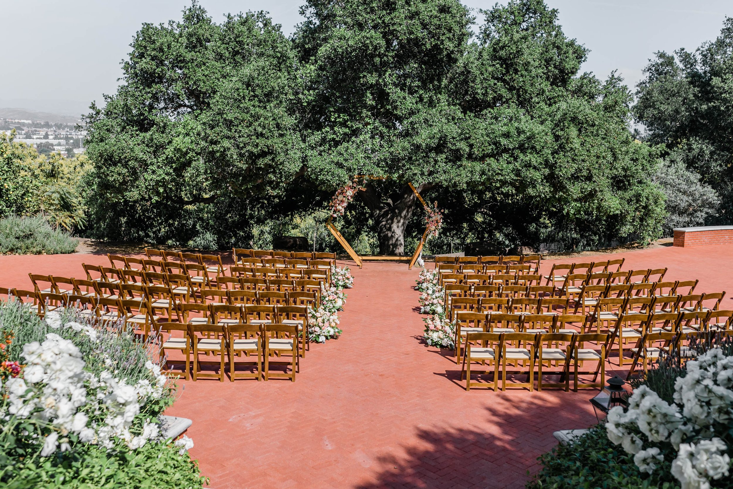 Outdoor ceremony space under tree at Spanish style ranch house at Quail Ranch events wedding venue in Simi Valley