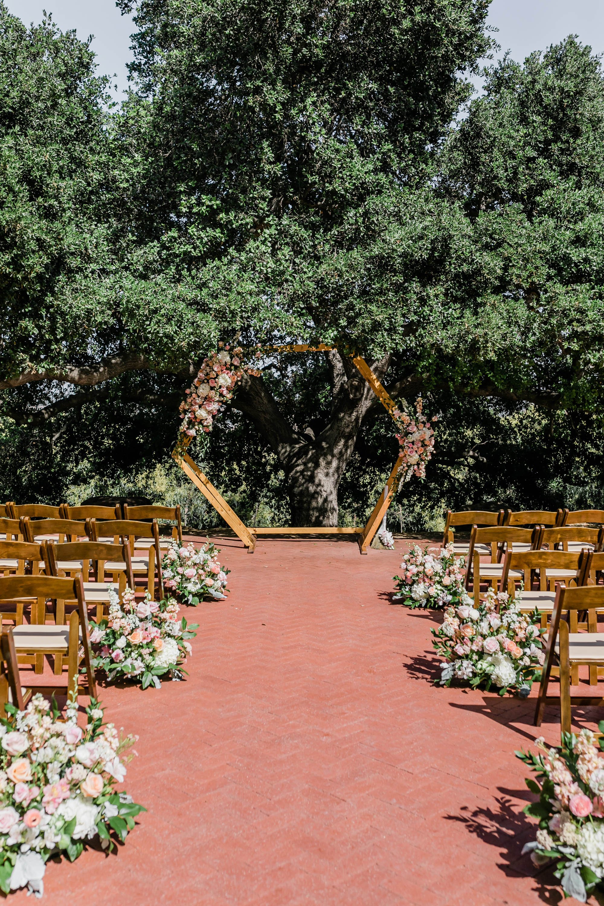Outdoor ceremony space under tree at Spanish style ranch house at Quail Ranch events wedding venue in Simi Valley