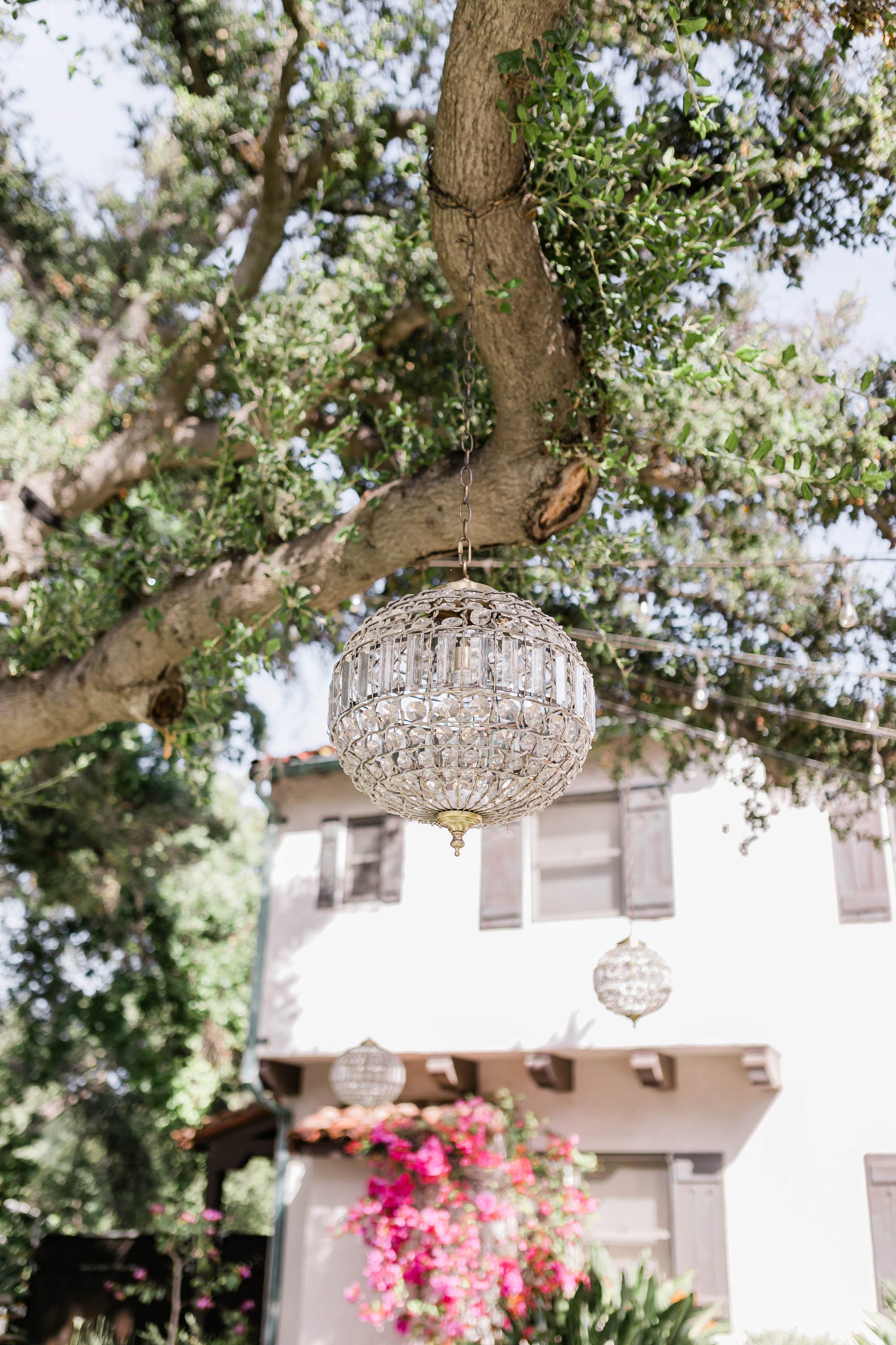 Outdoor reception space under tree with twinkle lights at Spanish style ranch house at Quail Ranch events wedding venue in Simi Valley
