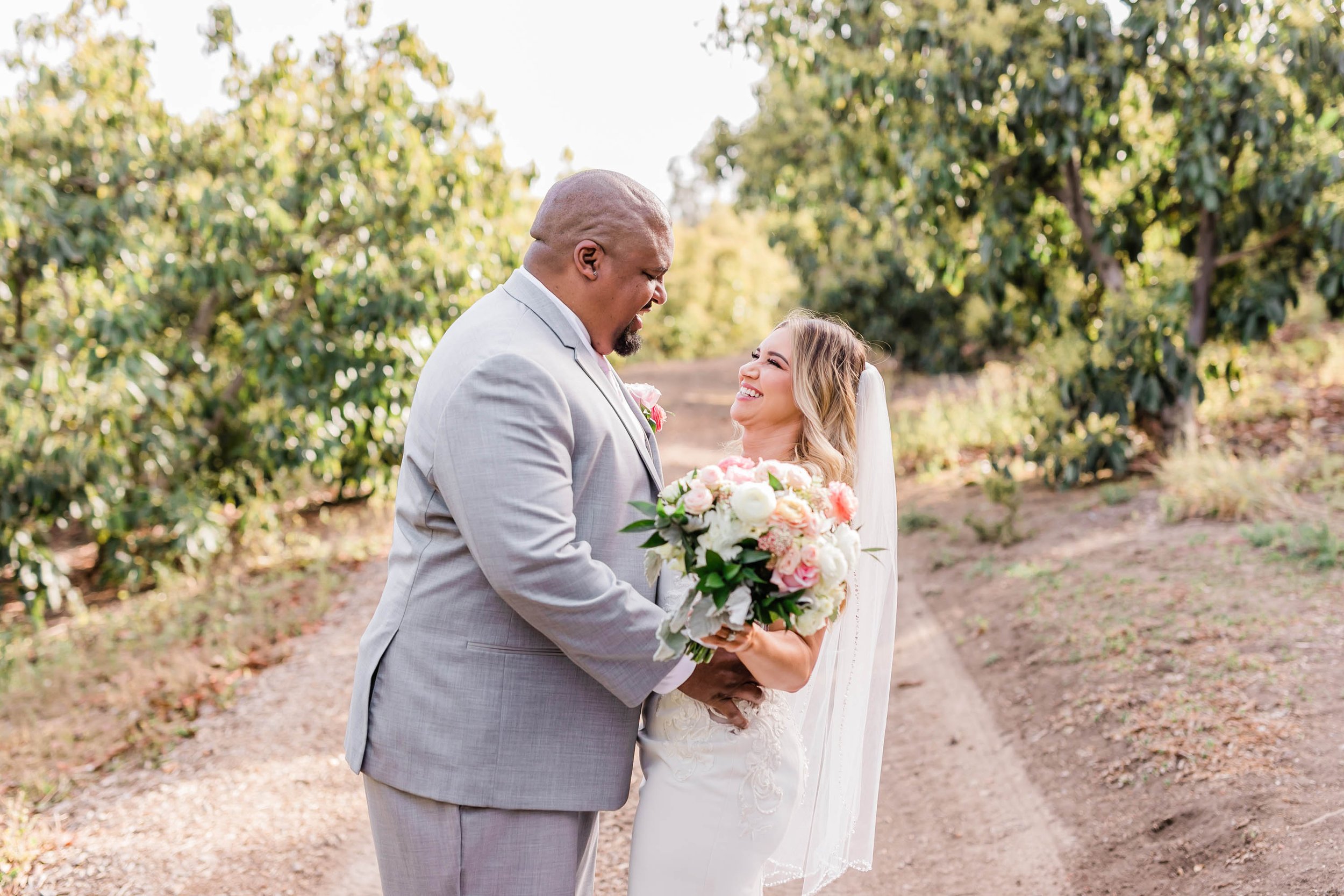 Bride and groom portraits in avocado orchard at Spanish style ranch house at Quail Ranch events weddin