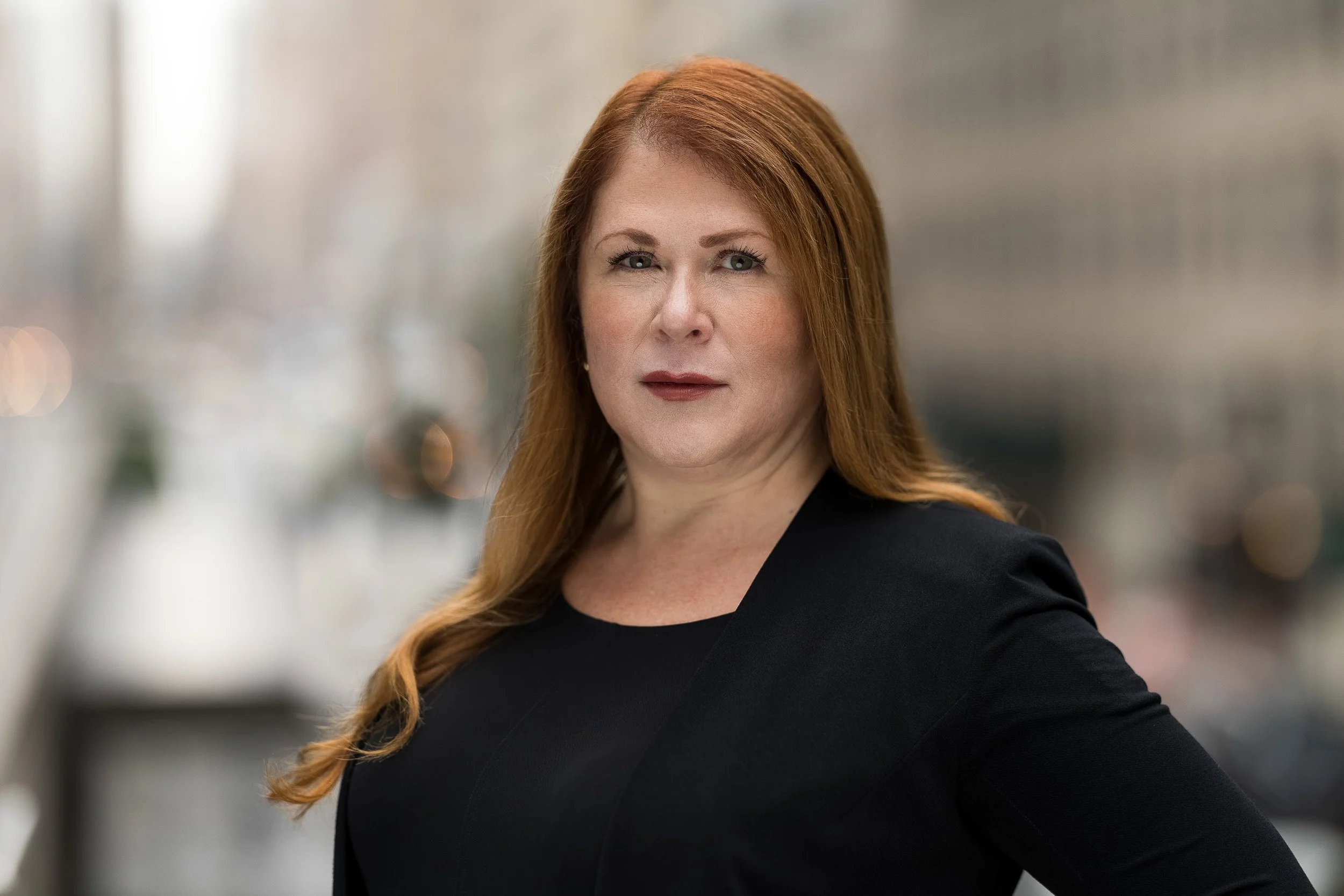 Natural light professional headshot of a woman with red hair taken outdoors in NYC