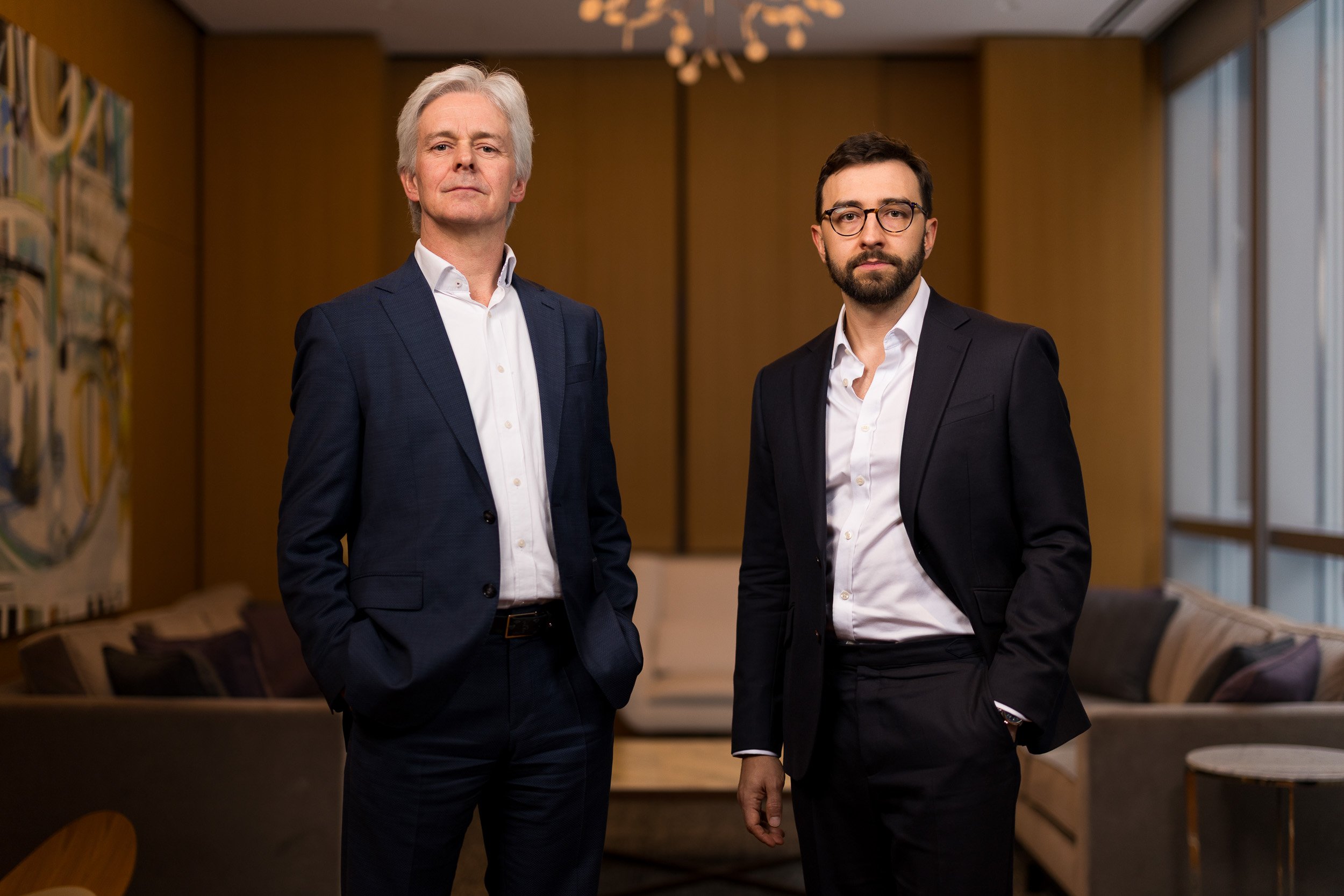 Corporate group photo of two white male company founders posing in their office