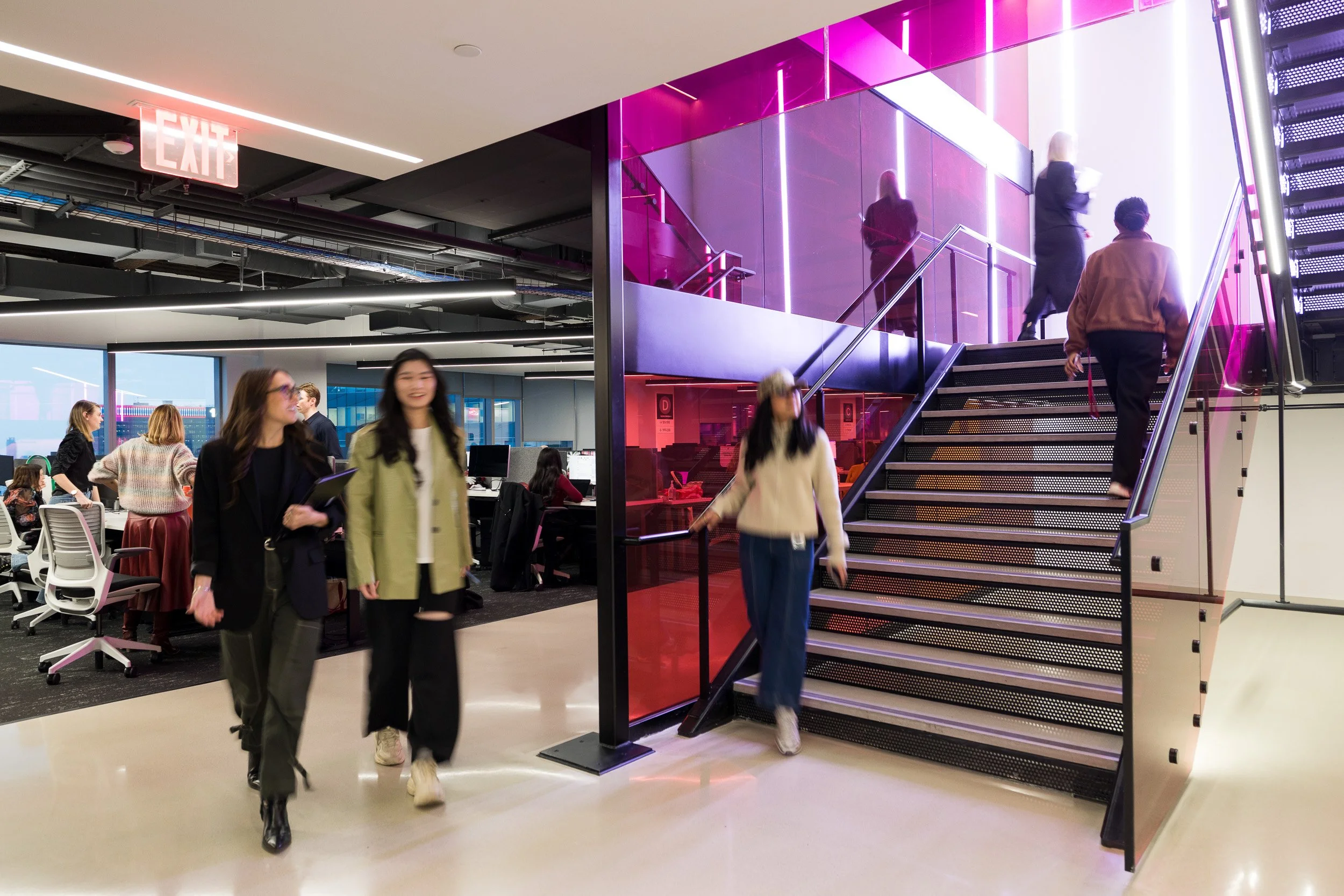 Busy office scene featuring employees moving through their workplace