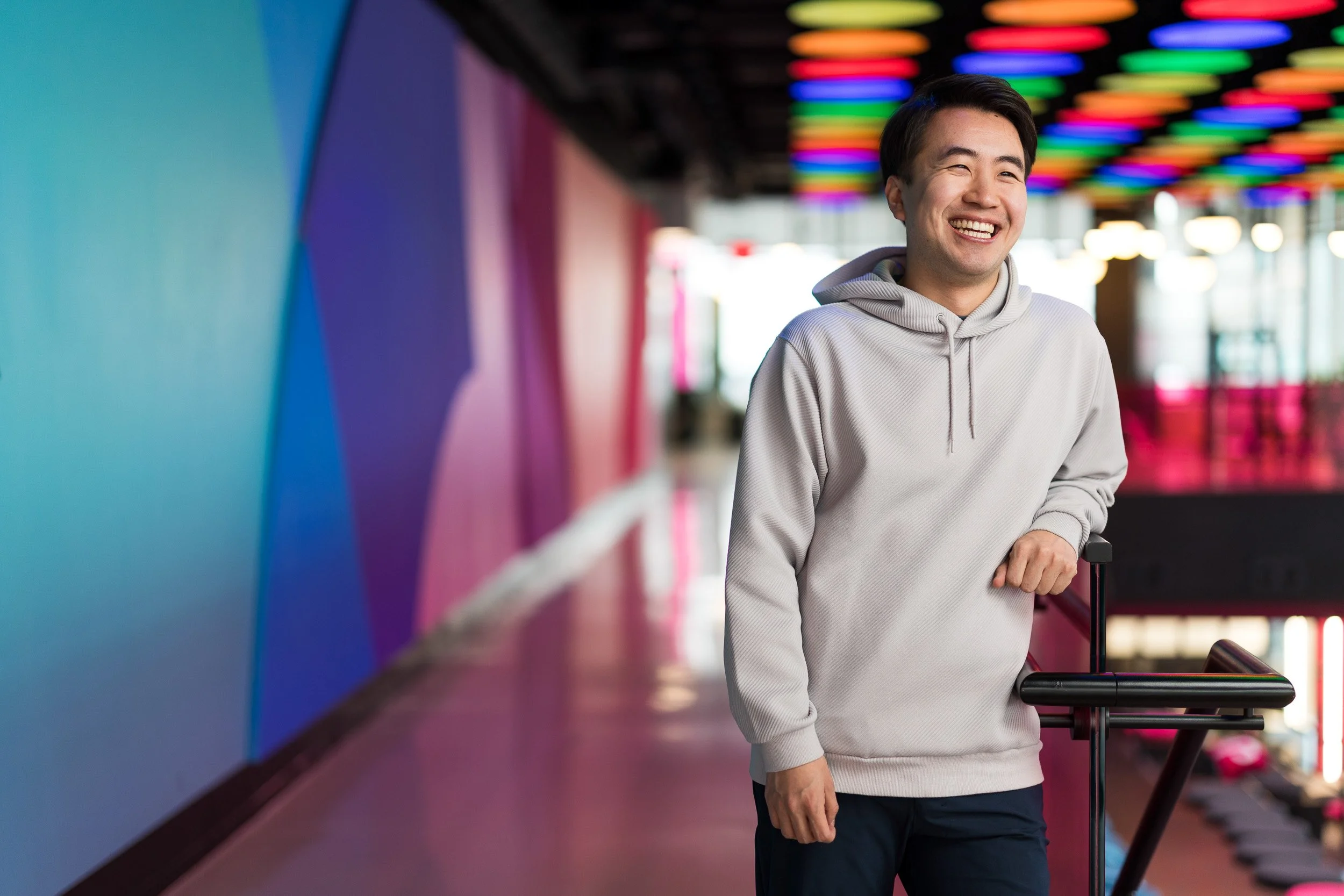 Creative corporate lifestyle portrait of young Asian male employee in an office with a colorful background