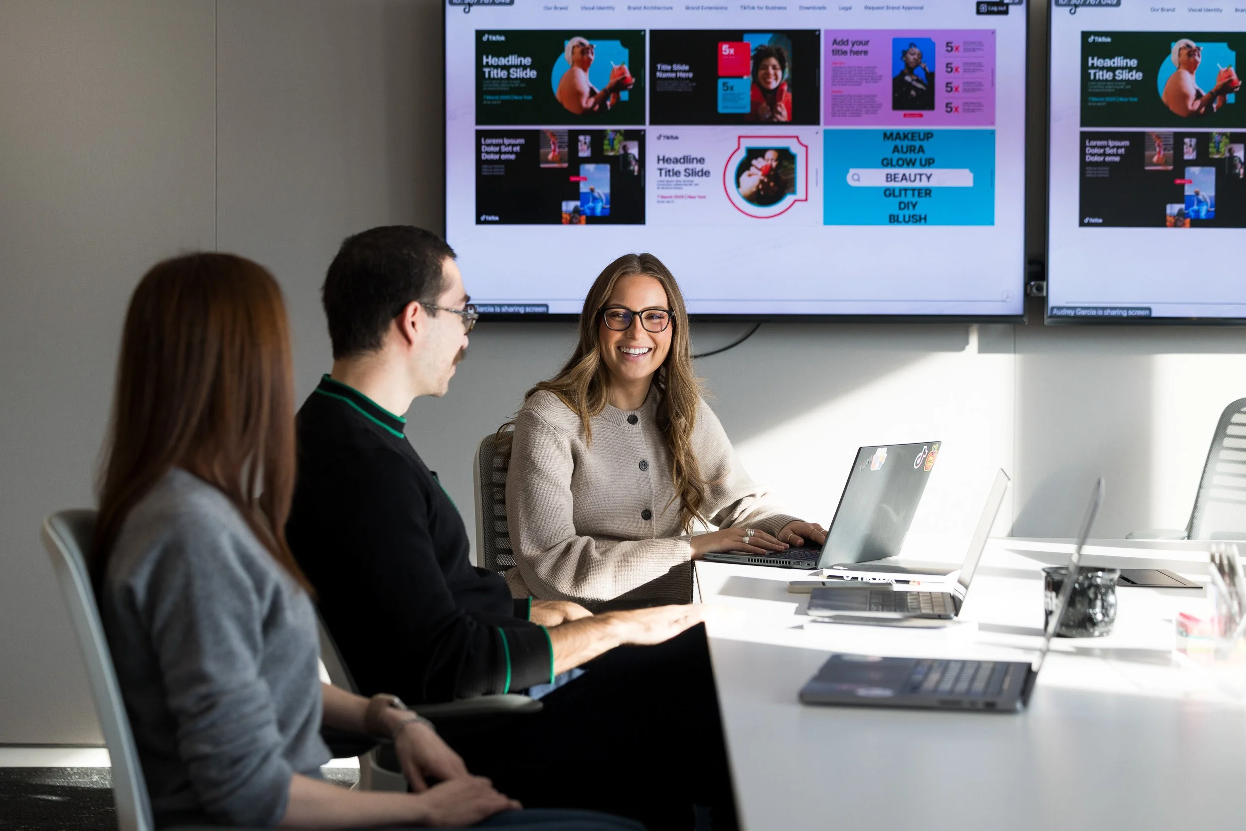 Coworking scene of 3 employees working in a conference room in the TikTok NYC office