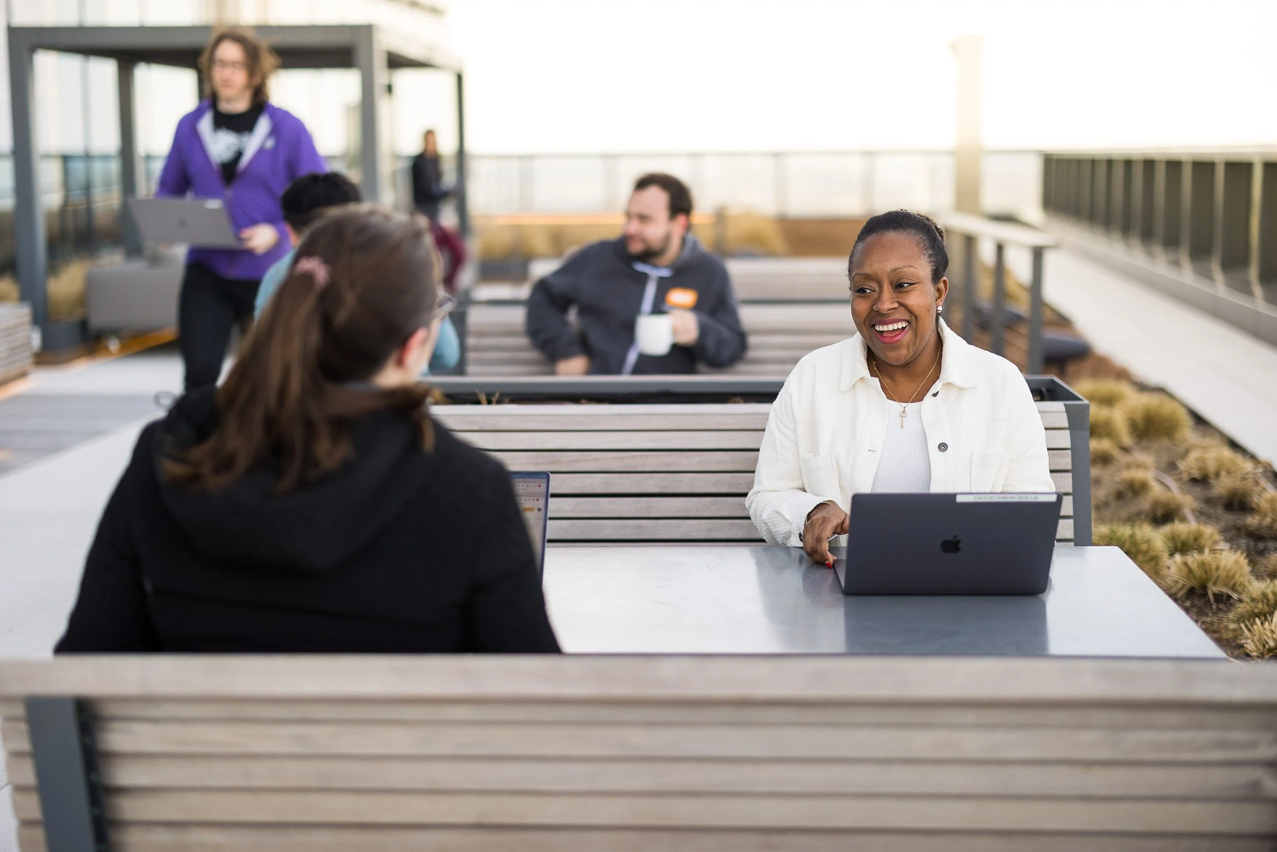 Corporate lifestyle photography showing a coworking scene of employees outside on their office's terrace in NYC.