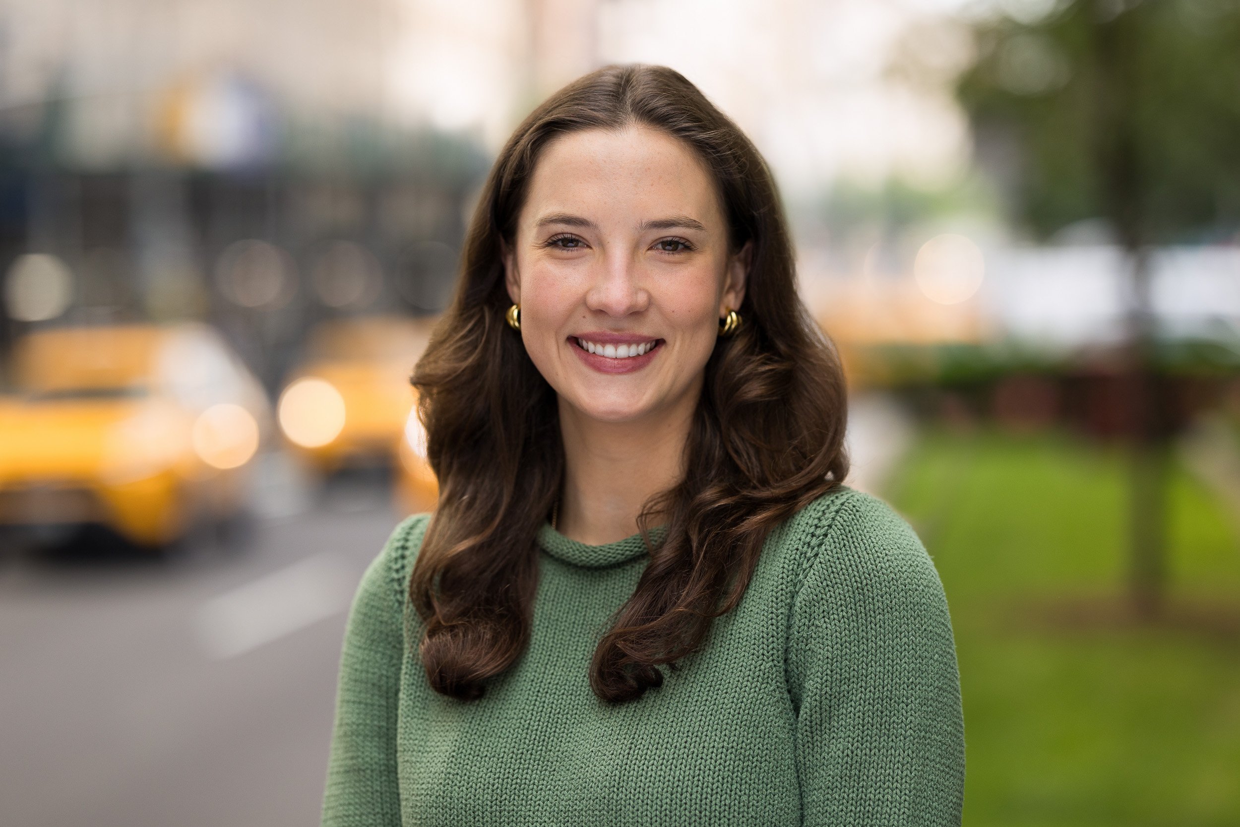 Modern corporate headshot of a young white female smiling outdoors in NYC