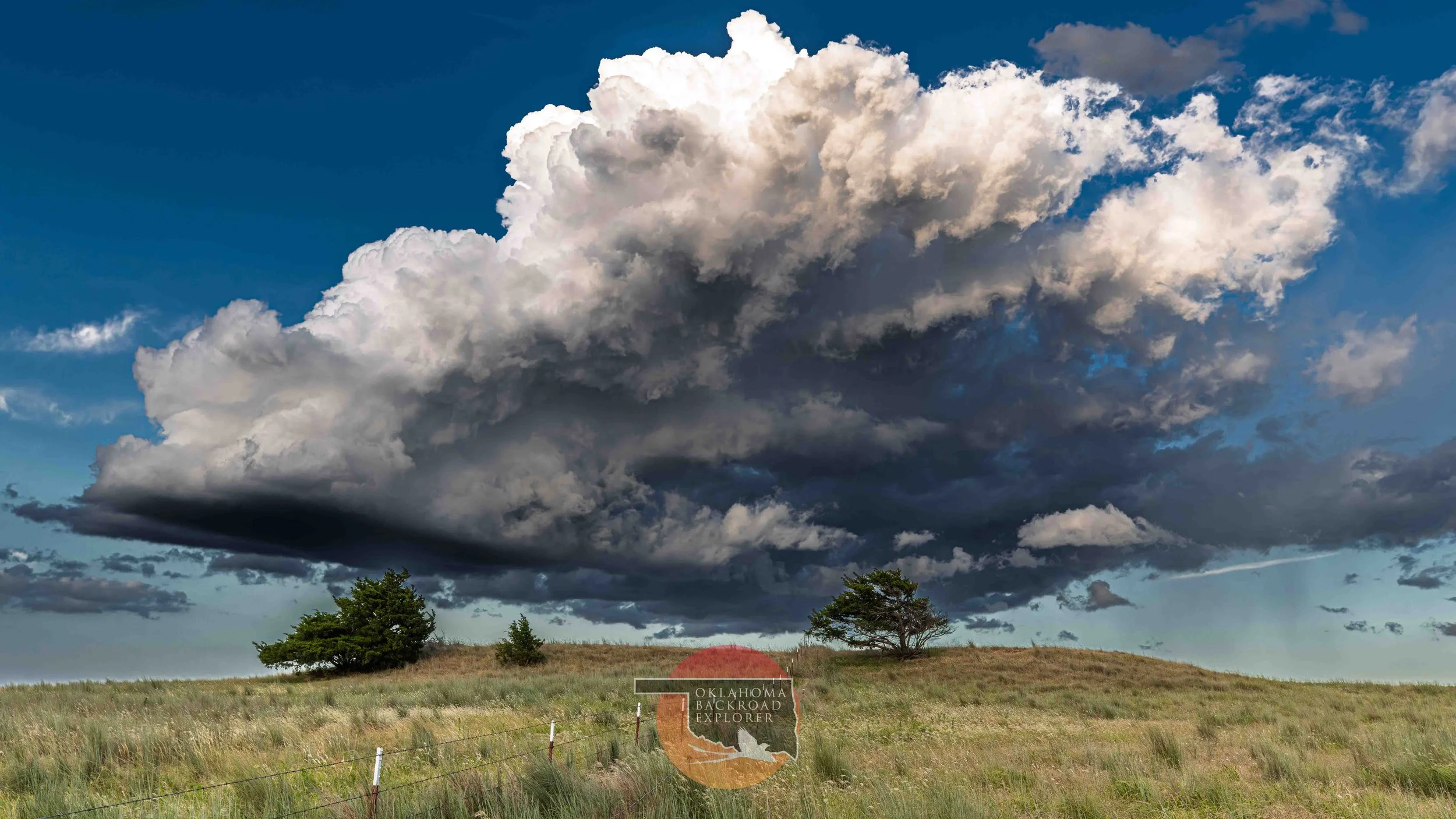 Massive supercell thunderstorm over rural Oklahoma, showcasing dramatic storm clouds, prairie grasslands, severe weather, storm chasing, and Great Plains landscapes.
