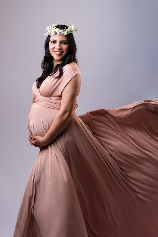 Pregnant woman in pink dress with floral crown