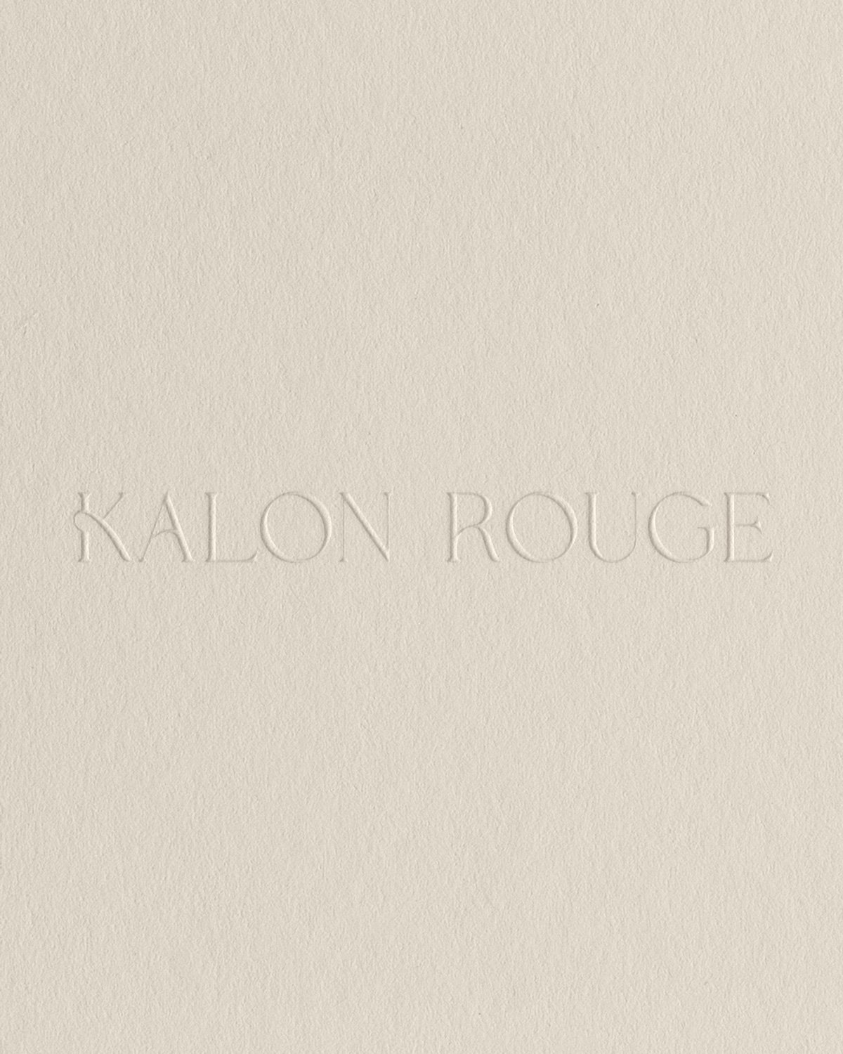 Kalon Rouge logo design blind embossed on stone colored textured paper