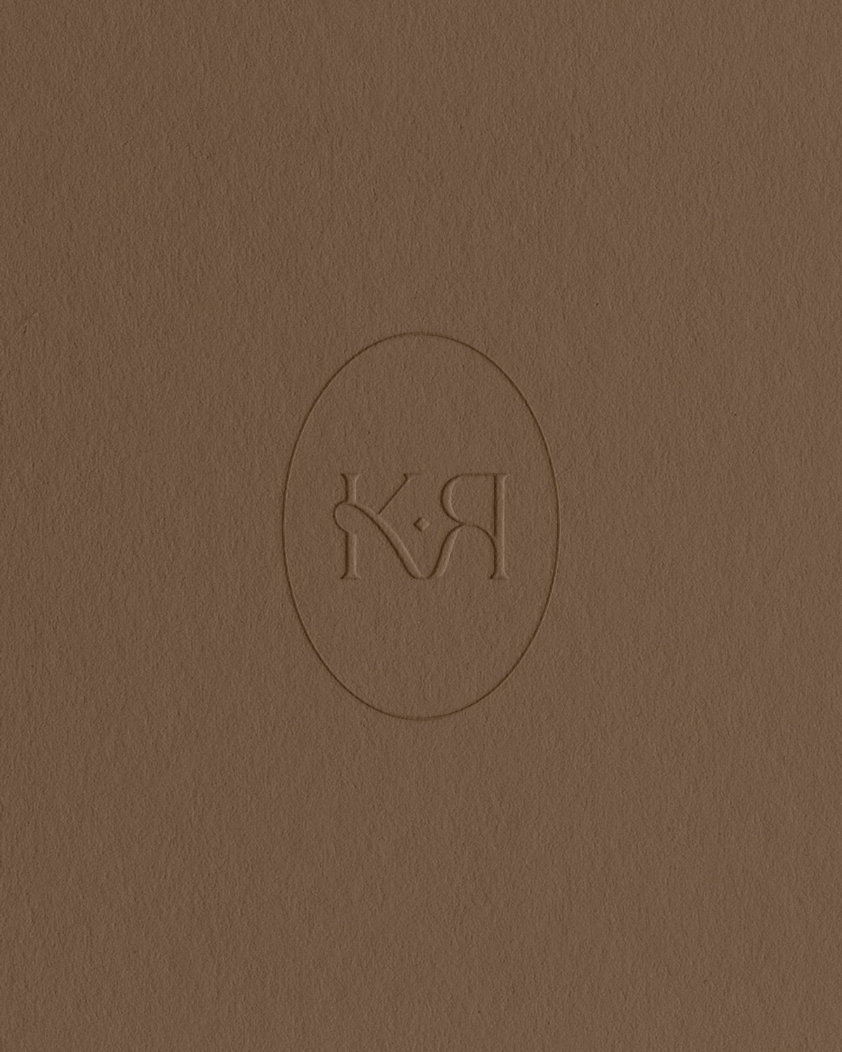 Brand Mark with letters KR for Kalon Rouge blind embossed on brown textured paper