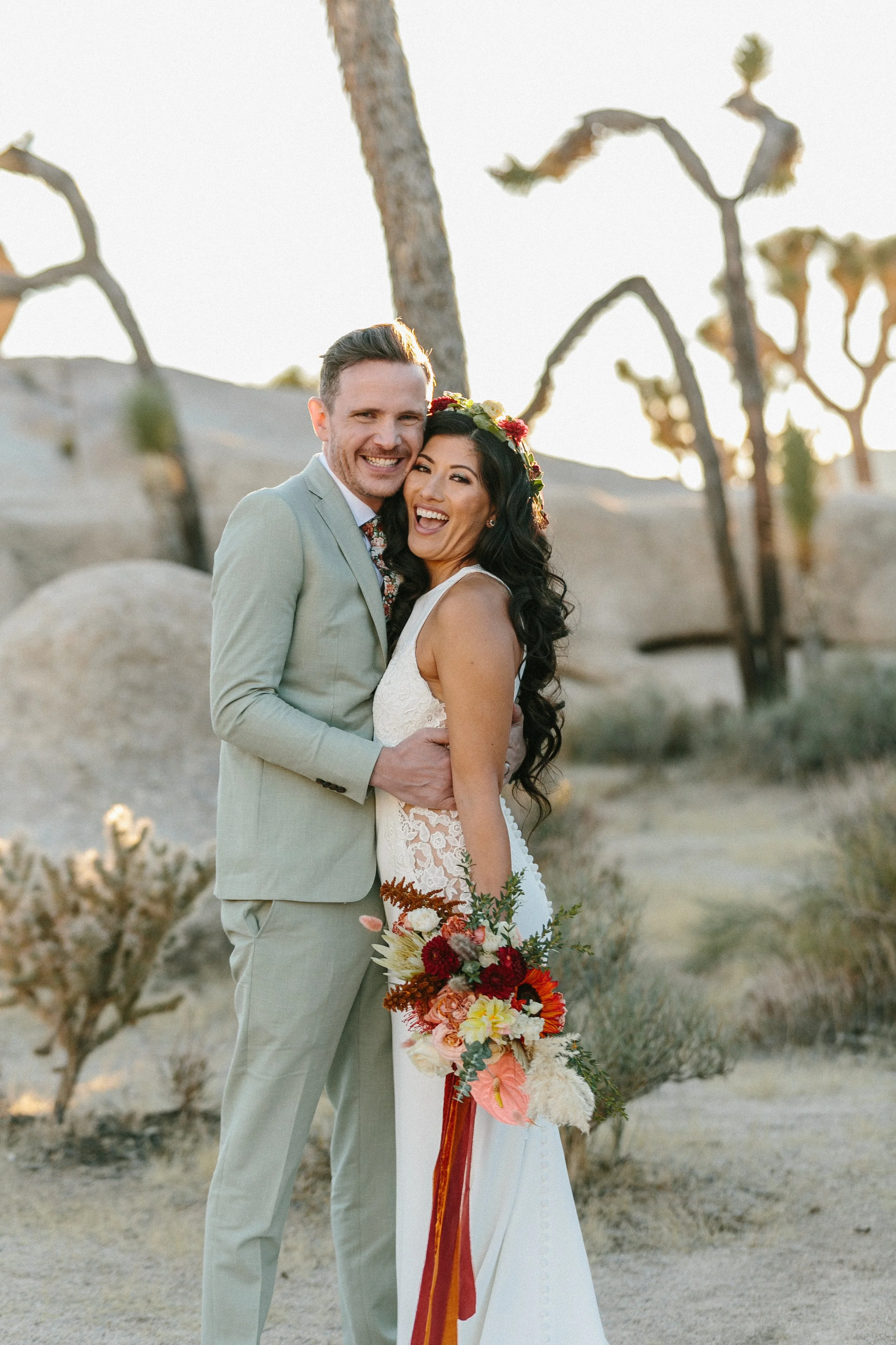 Bride holding floral bouquet and groom in Joshua Tree intimate wedding makeup artist and hairstyling