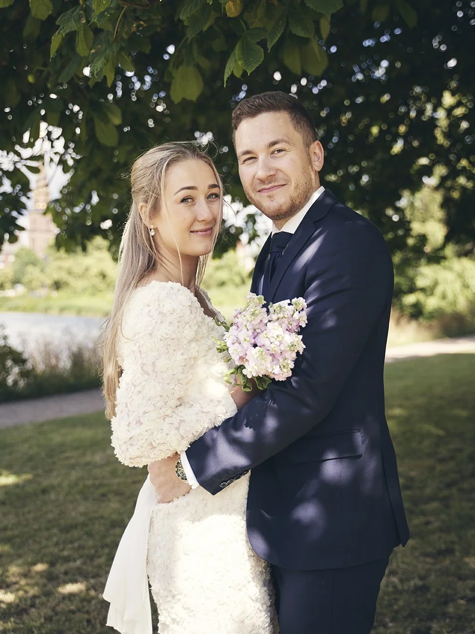 Brudepar står tæt med buket – bryllupsfoto