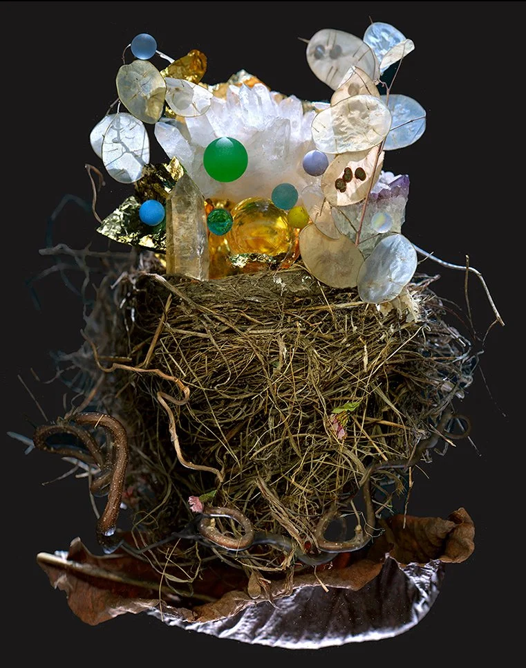 mercy center show announcement image, floating nest filled with symbols of abundance like gold leaf, lunaria plant smoky crystal, handmade rainbow marble, small crystal ball