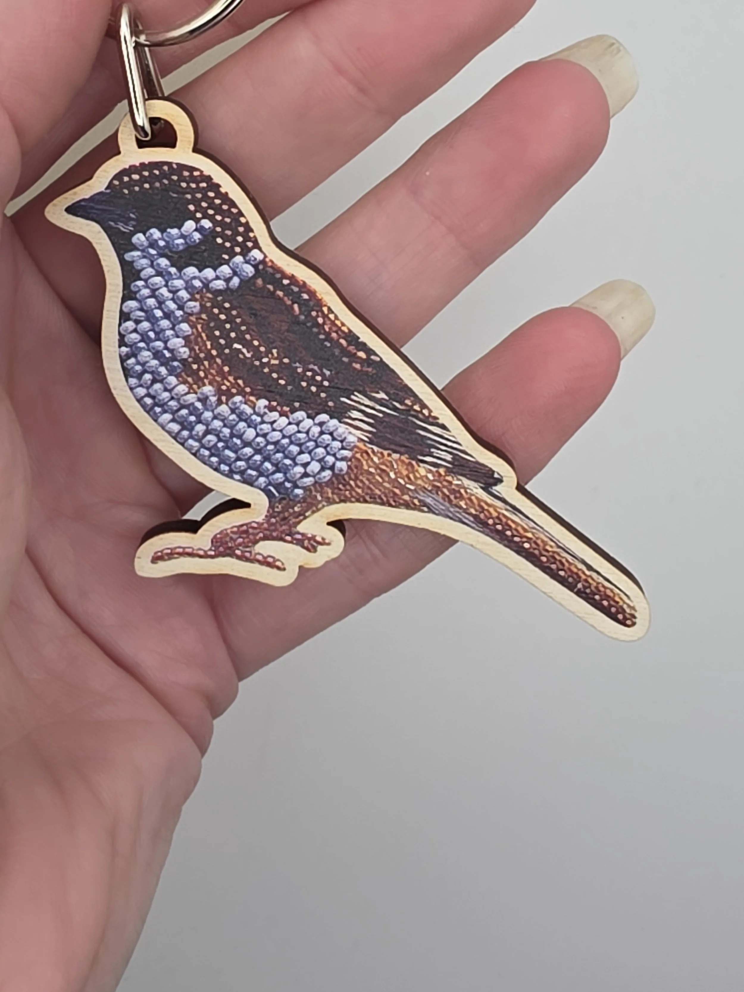 Eurasian Tree Sparrow wooden keyring held in hand to show size, featuring original bead embroidery artwork by Hayley Mallett
